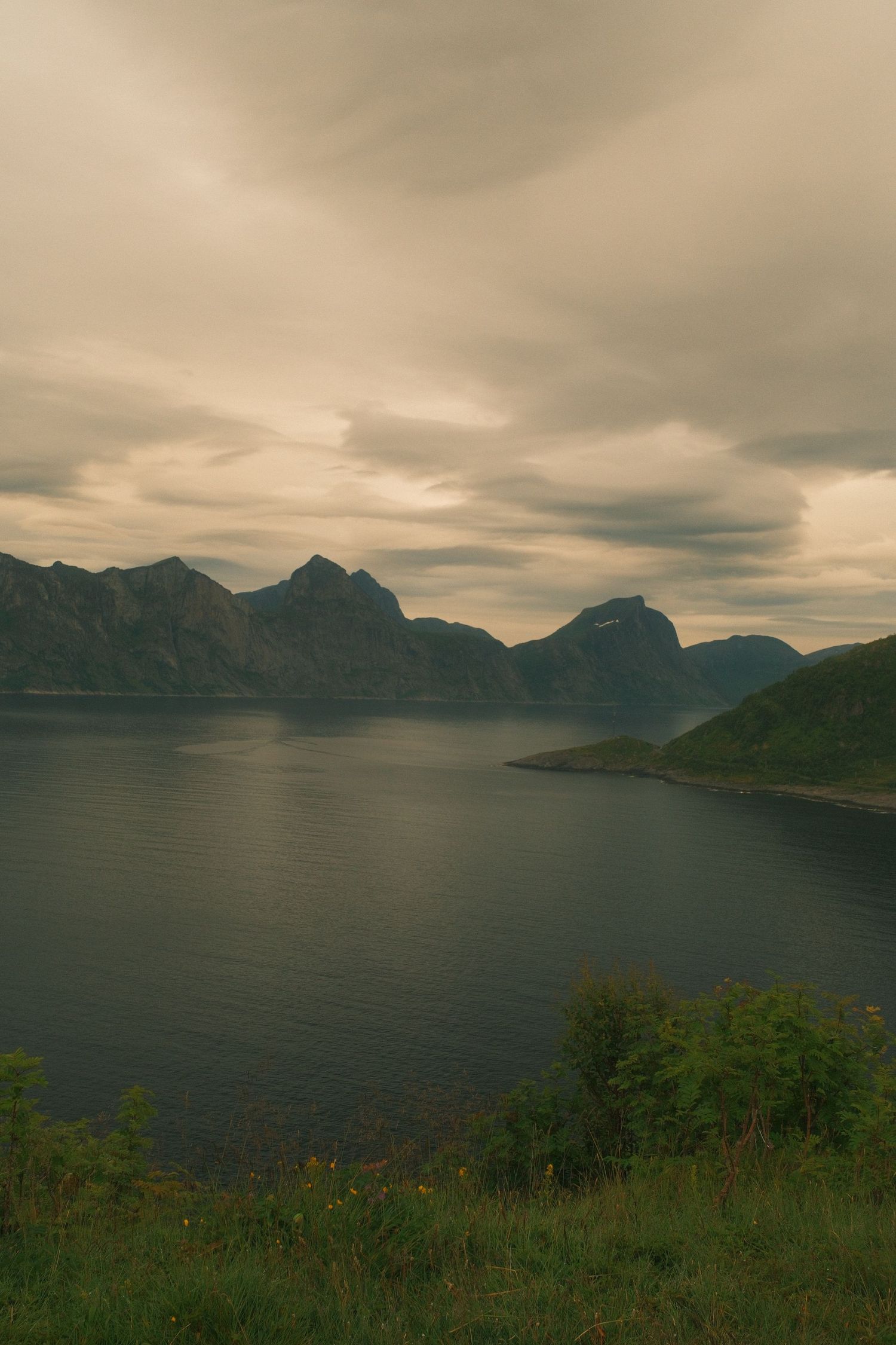Steep mountains rising above a quiet fjord on Senja, northern Norway