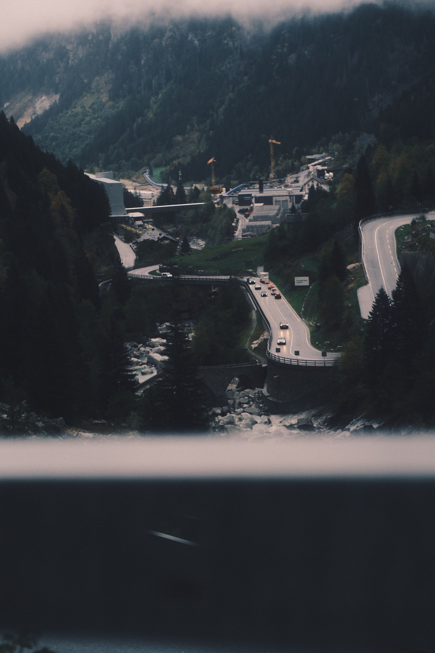 View down into a narrow Swiss valley with a motorway and village from the Gotthard Pass