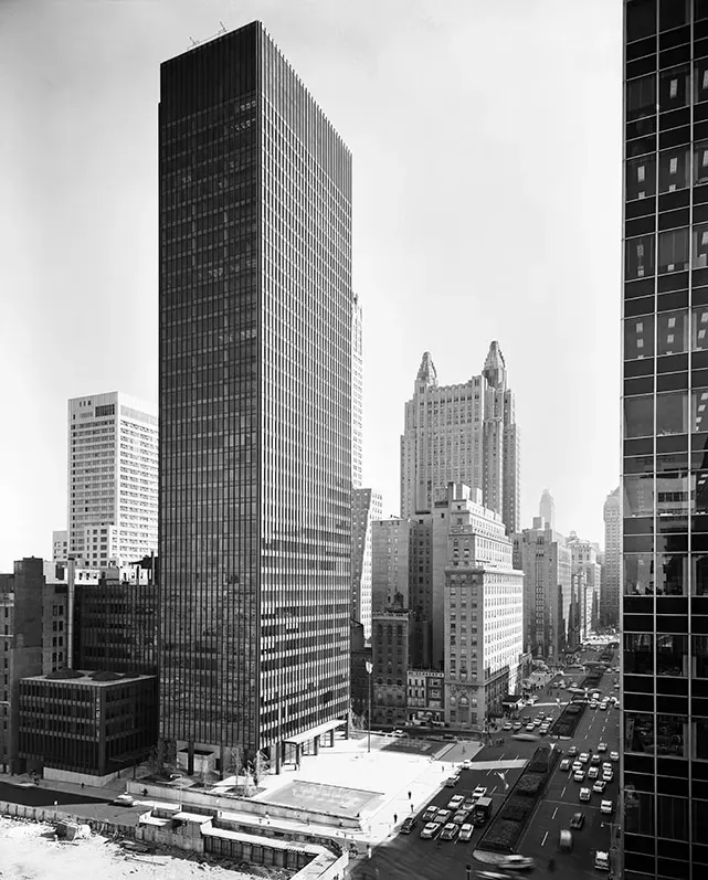 Black and white aerial view of Manhattan skyscrapers along a busy city street in New York City.