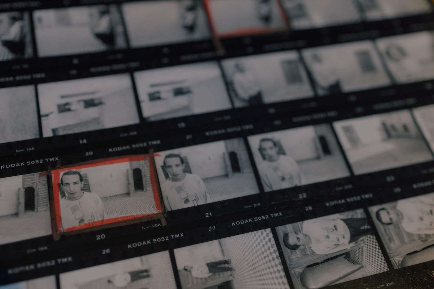 Black and white film contact sheet showing multiple photographic frames with two highlighted images of a woman.