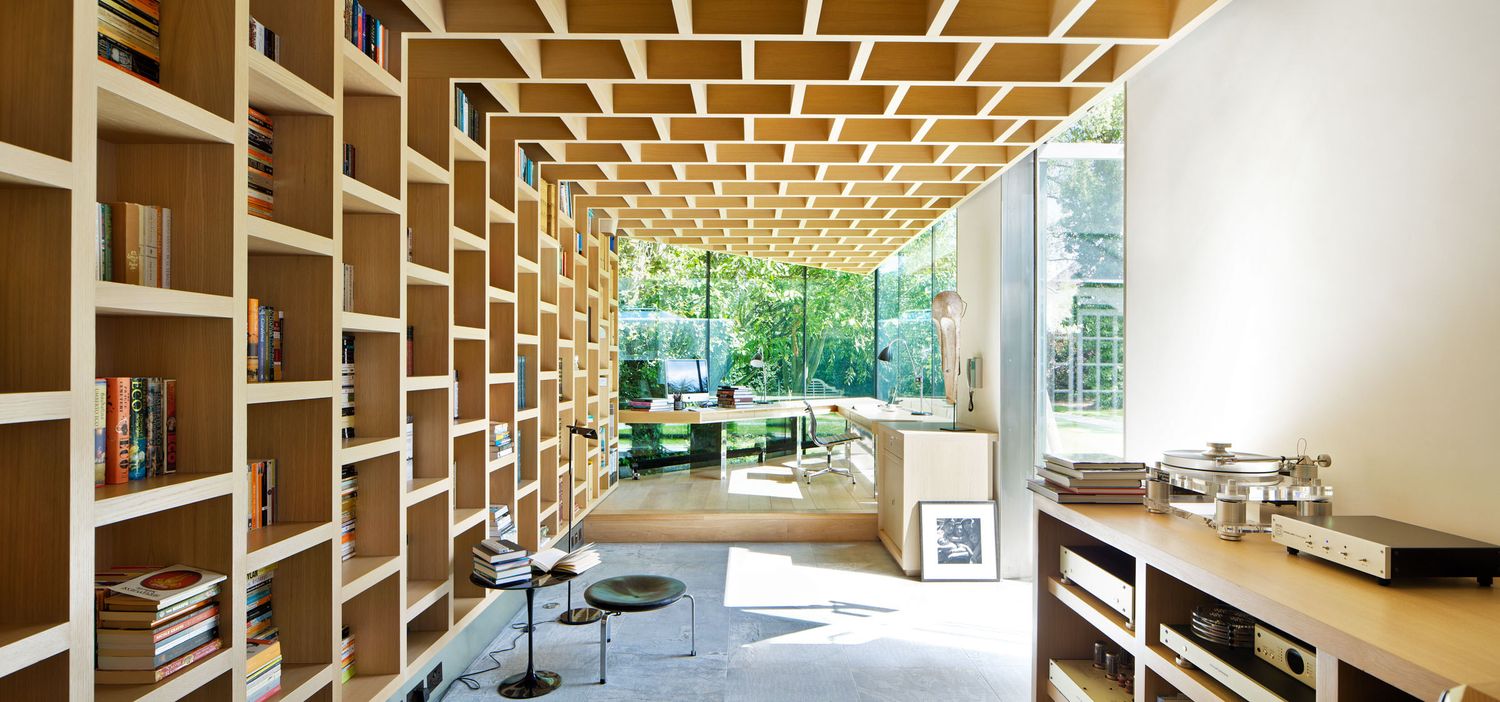 Bright modern library with floor-to-ceiling wooden bookshelves and a garden view.