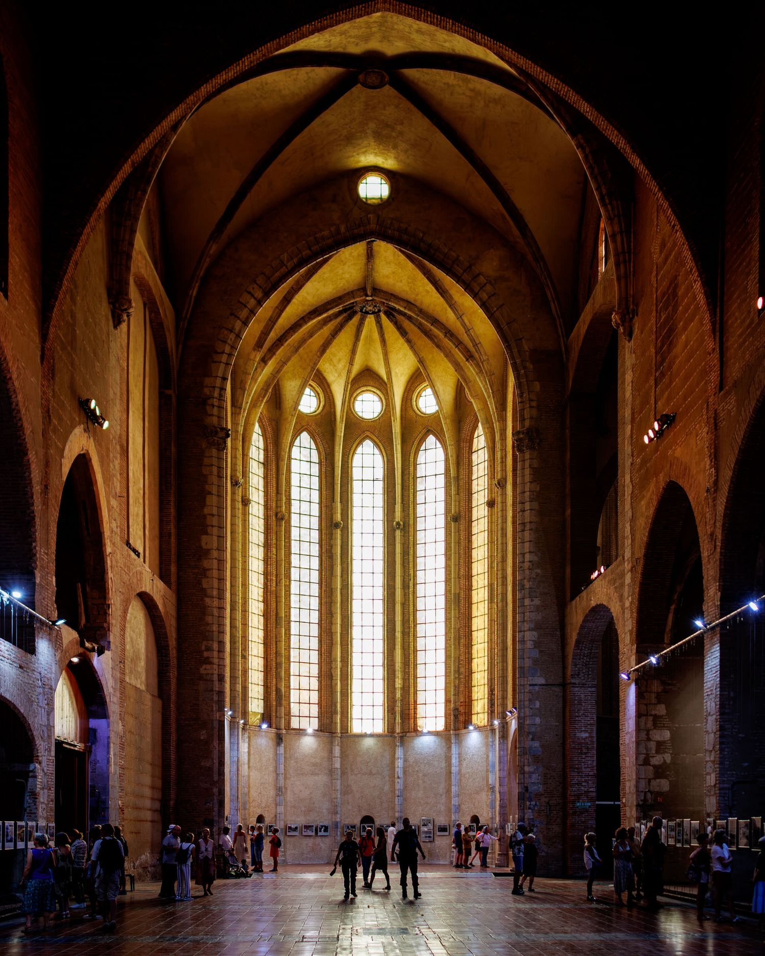 Gothic cathedral interior with vaulted arches and tall windows hosting festival visitors.