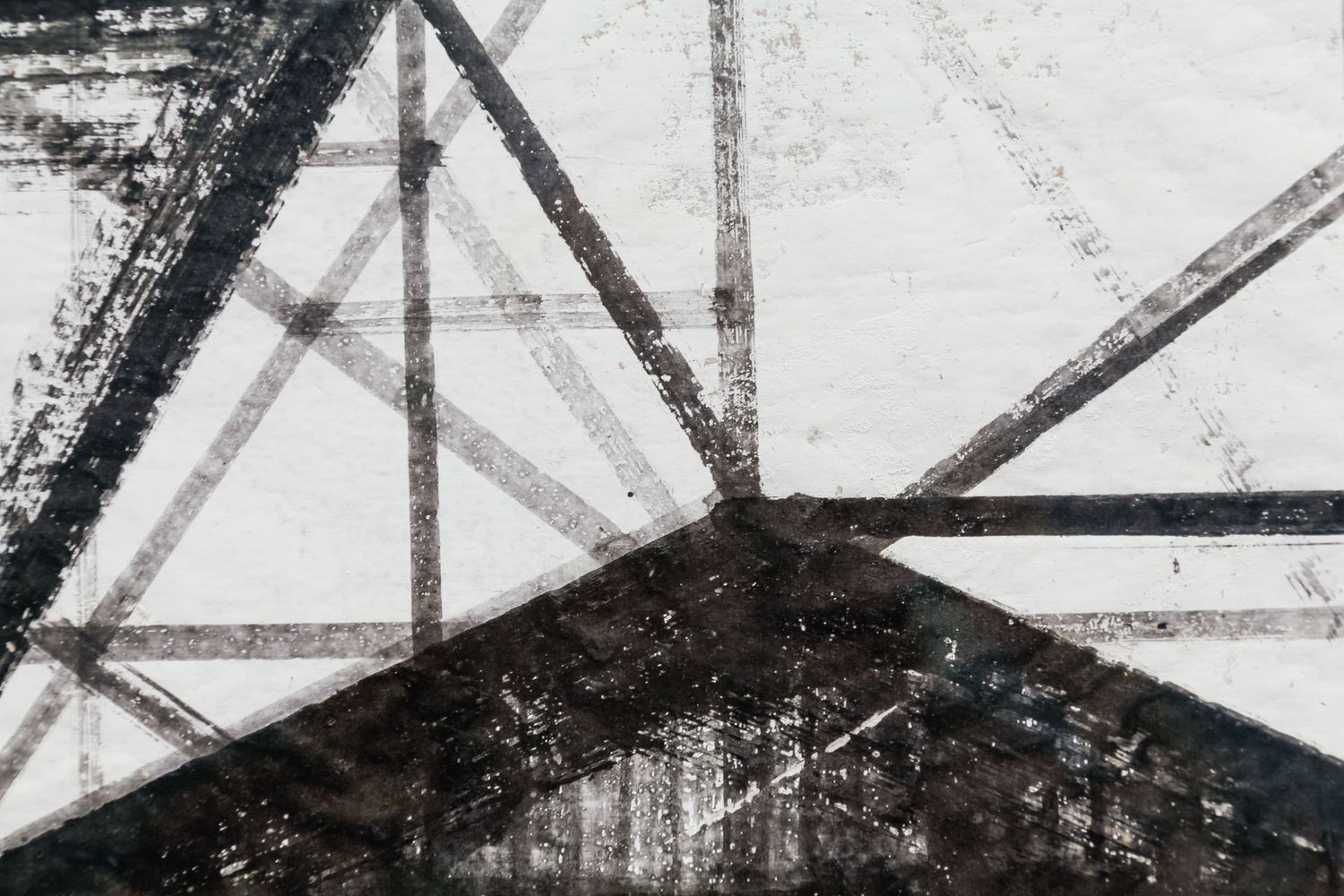 Abstract black and white geometric artwork featuring intersecting diagonal lines and triangular shapes with a grunge texture.