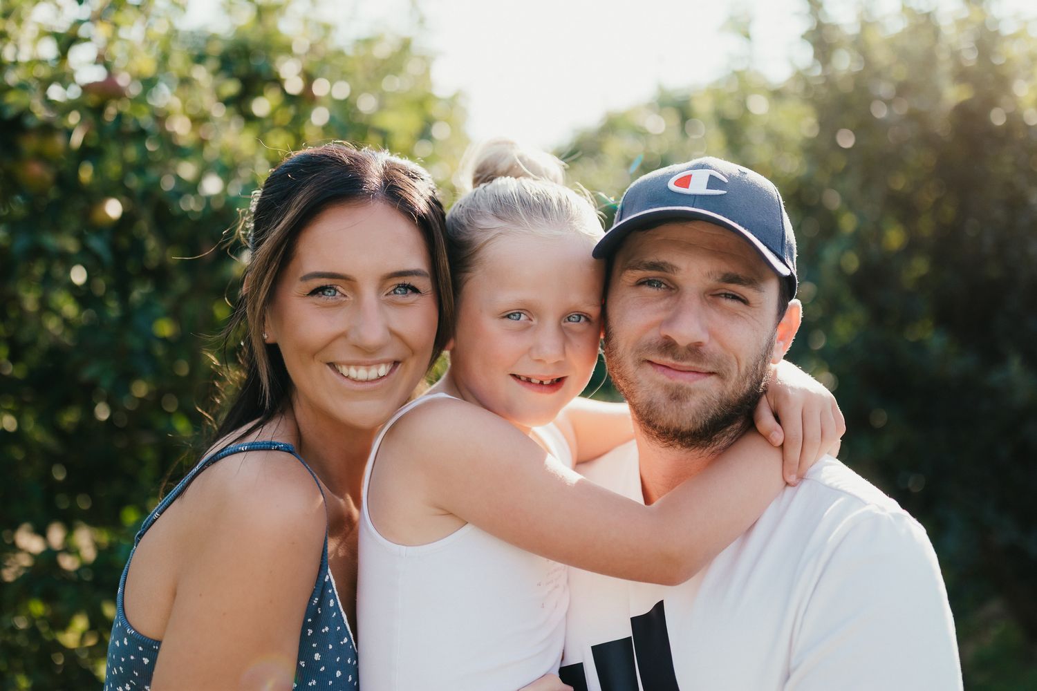 Relaxed family photo session at the farm. Summer evening. Mum Dad & Daughter. golden backlit portraits.