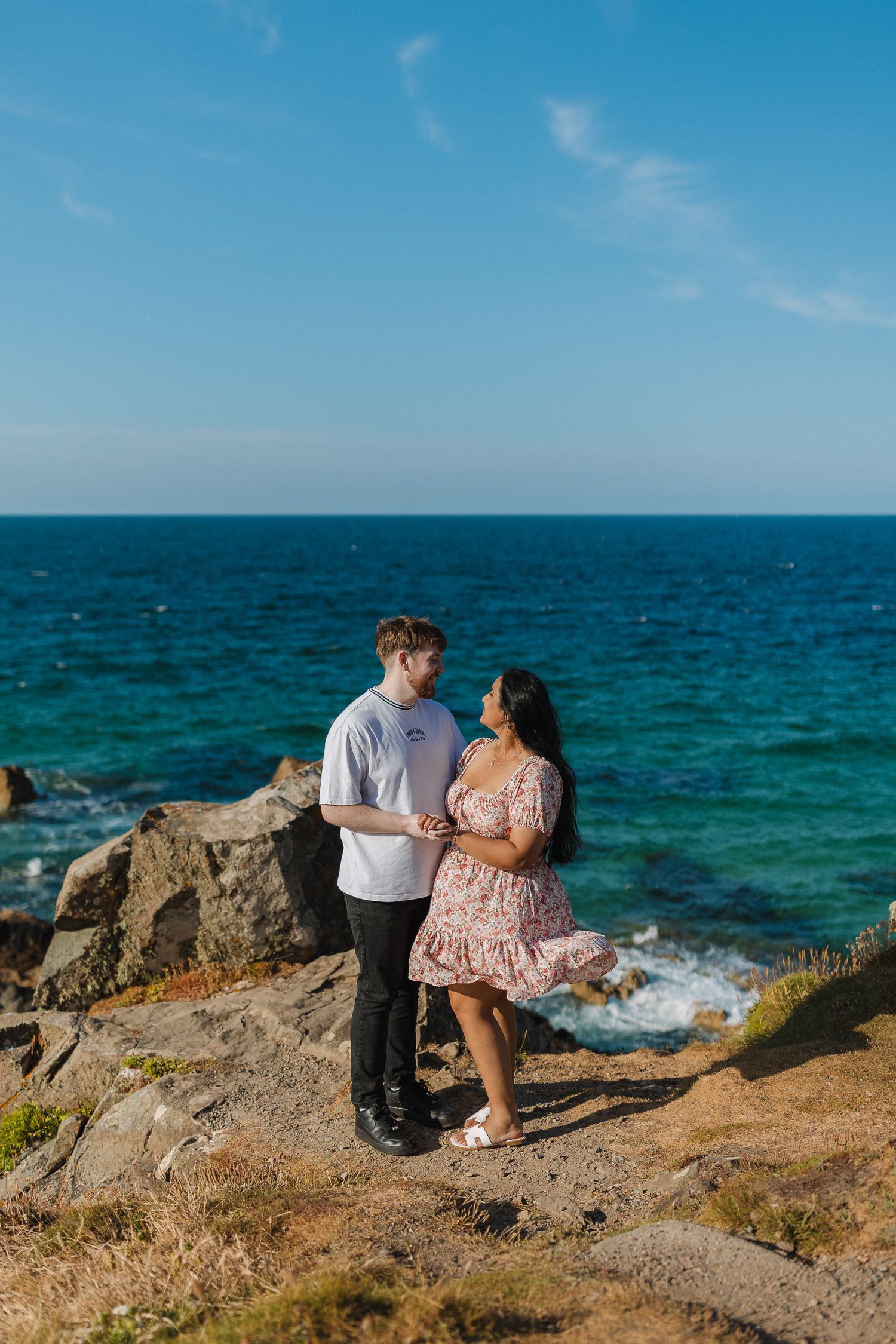 Surprise proposal on The Island, St.Ives. Blue skies & sea. Colourful engagement photos.