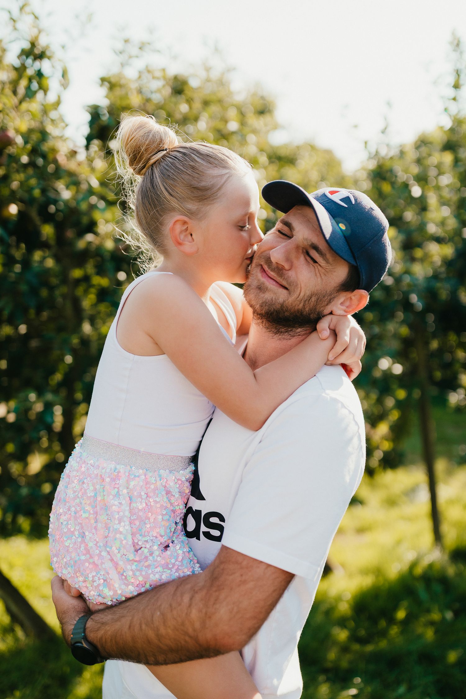 Relaxed family photo session at the farm. Summer evening. Mum Dad & Daughter. golden backlit portraits.