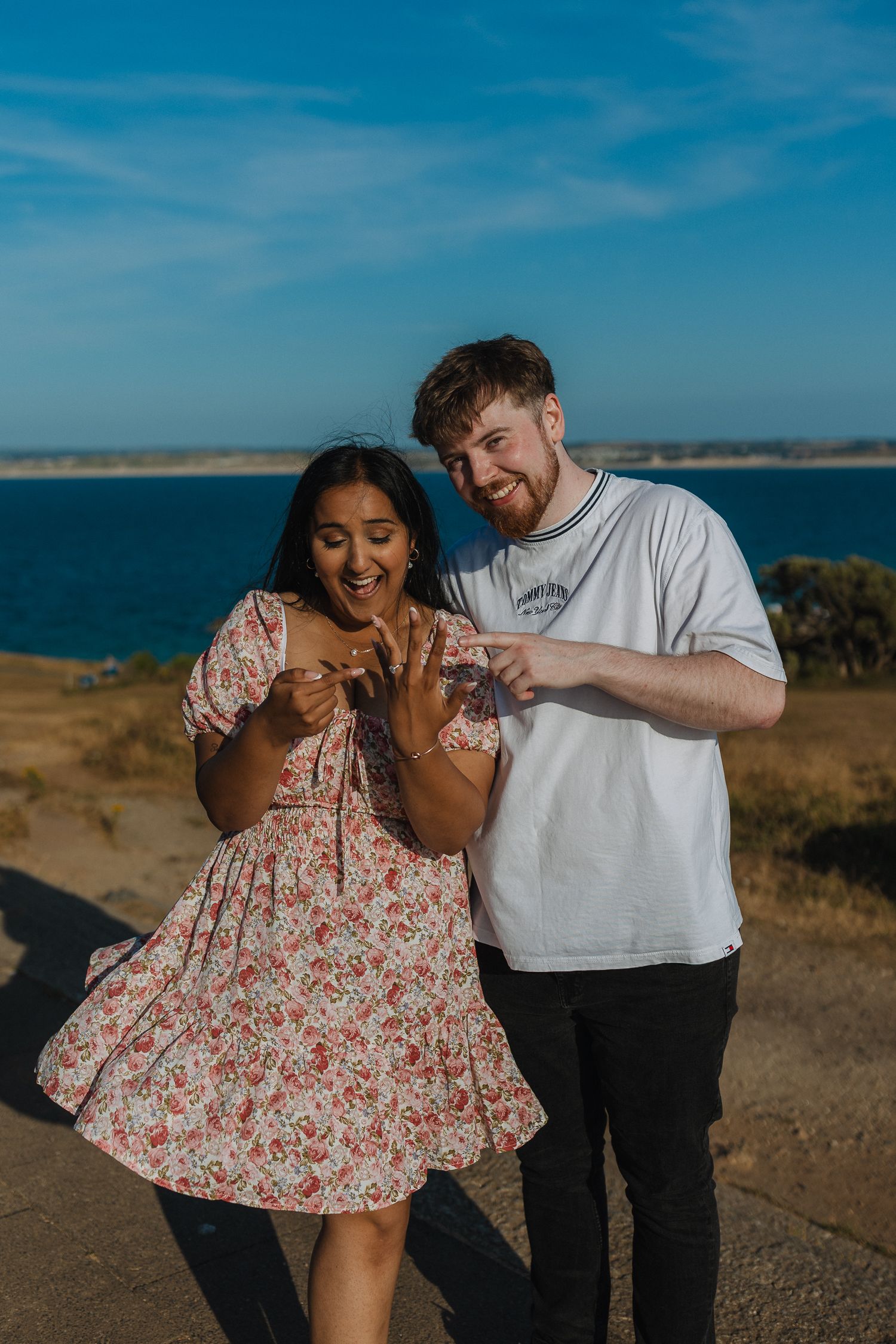 Surprise proposal on The Island, St.Ives. Blue skies & sea. Colourful engagement photos.