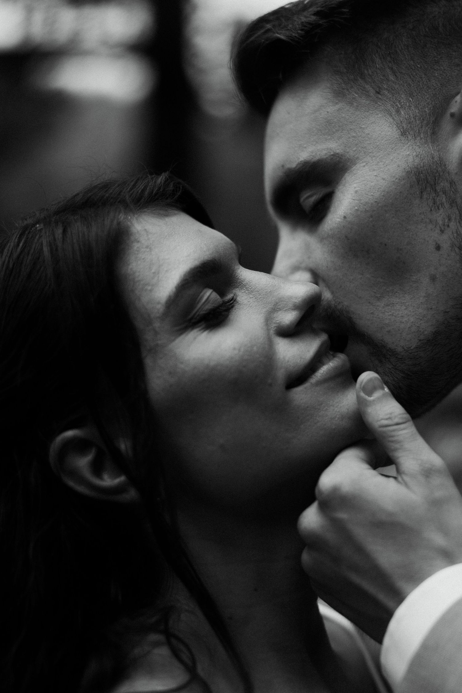 Intimate black and white close-up portrait of bride and groom about to share a kiss.