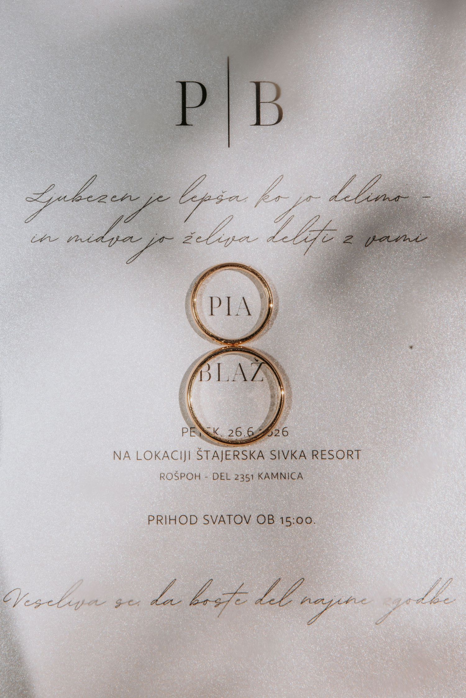 Two gold wedding rings on a Slovenian wedding invitation for Pia and Blaz at Stajerska Sivka Resort.