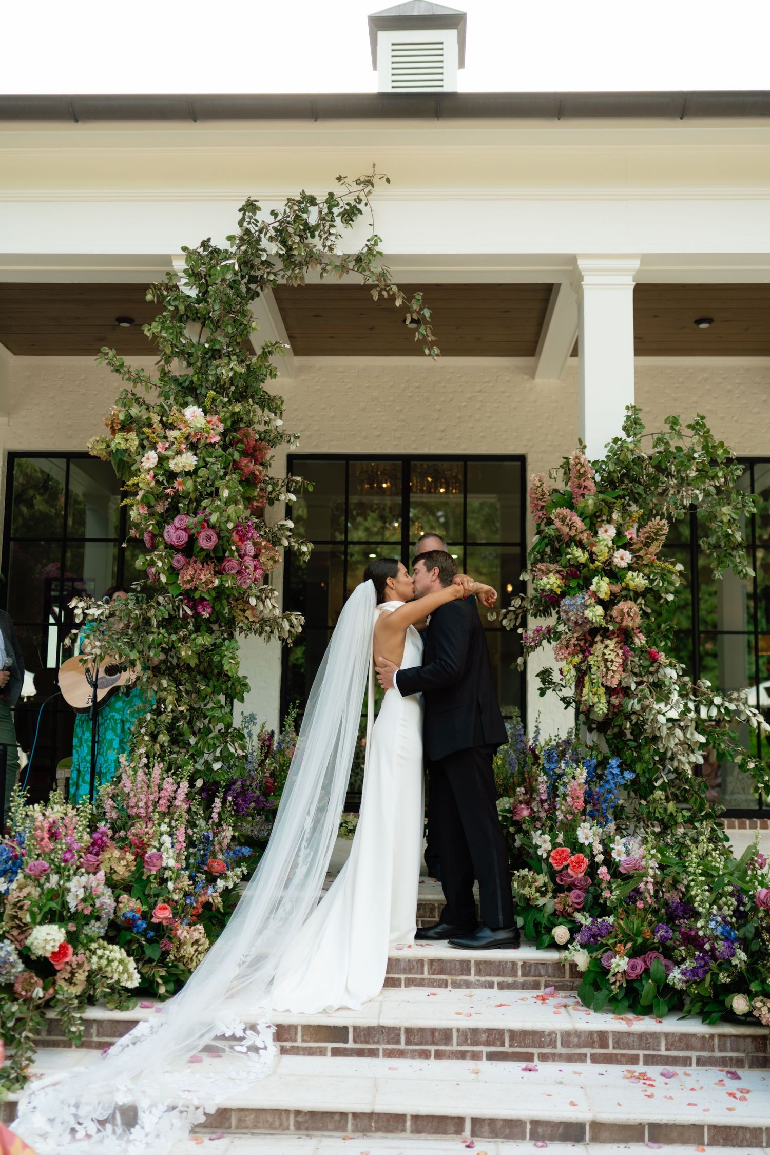a newlywed couple sharing their first kiss as husband and wife at their wedding.