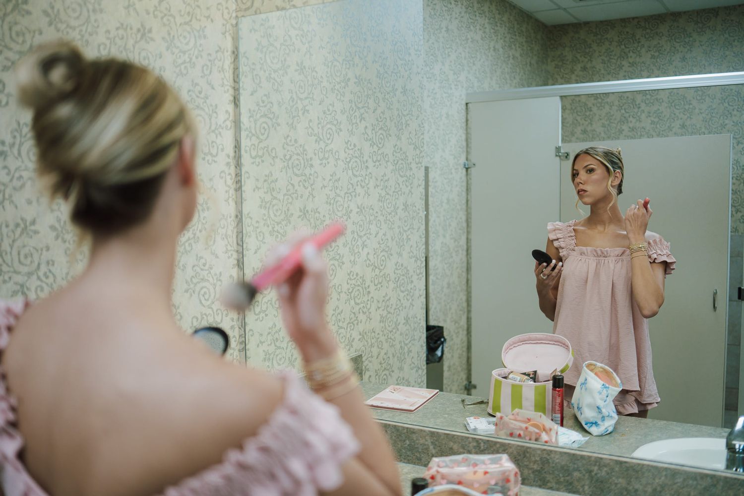 a bridesmaid putting on makeup