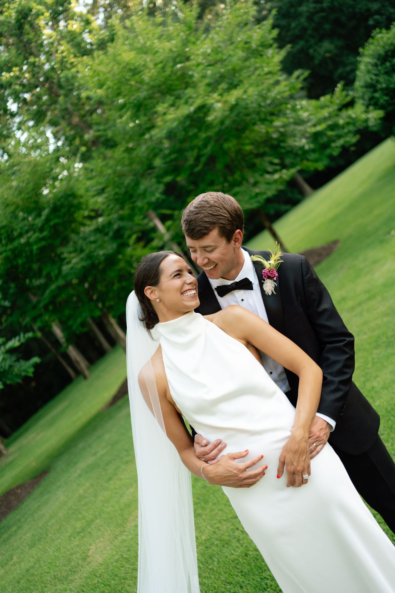 A newlywed couple hugging and laughing during after getting married.