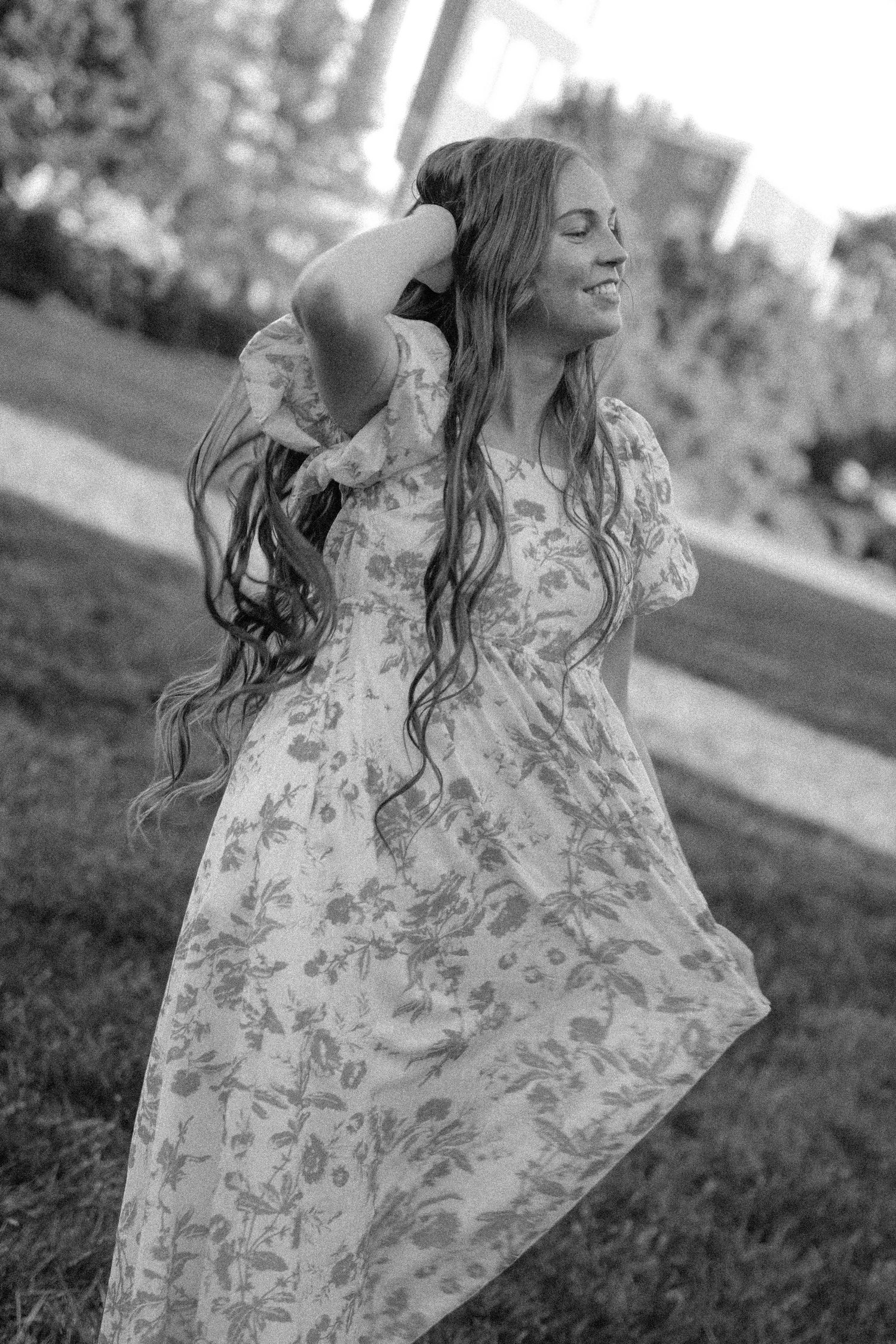 a black and white photo of a college senior girl with her hand in her hair