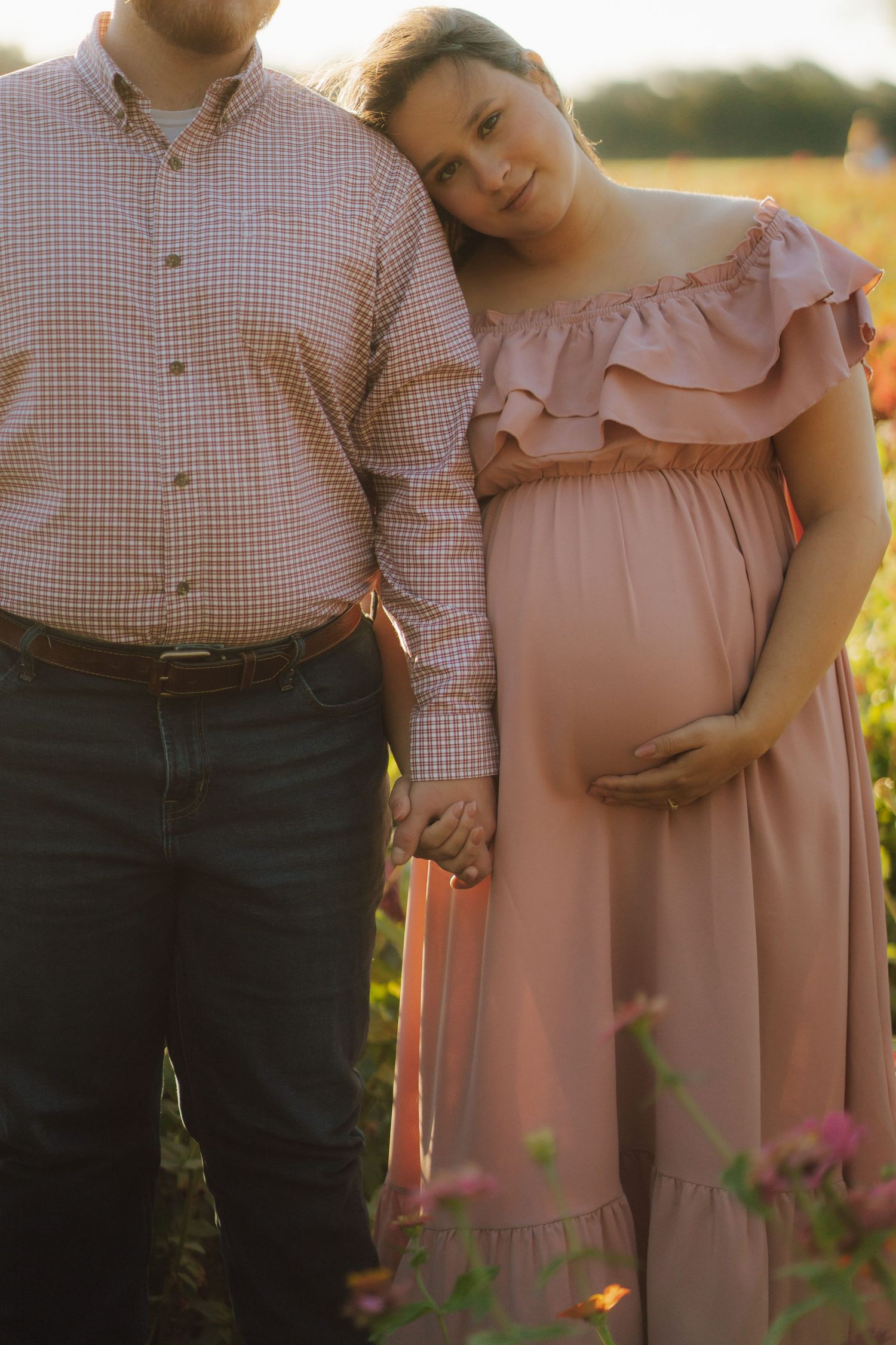 a pregant wife holding her stomach next to her husband