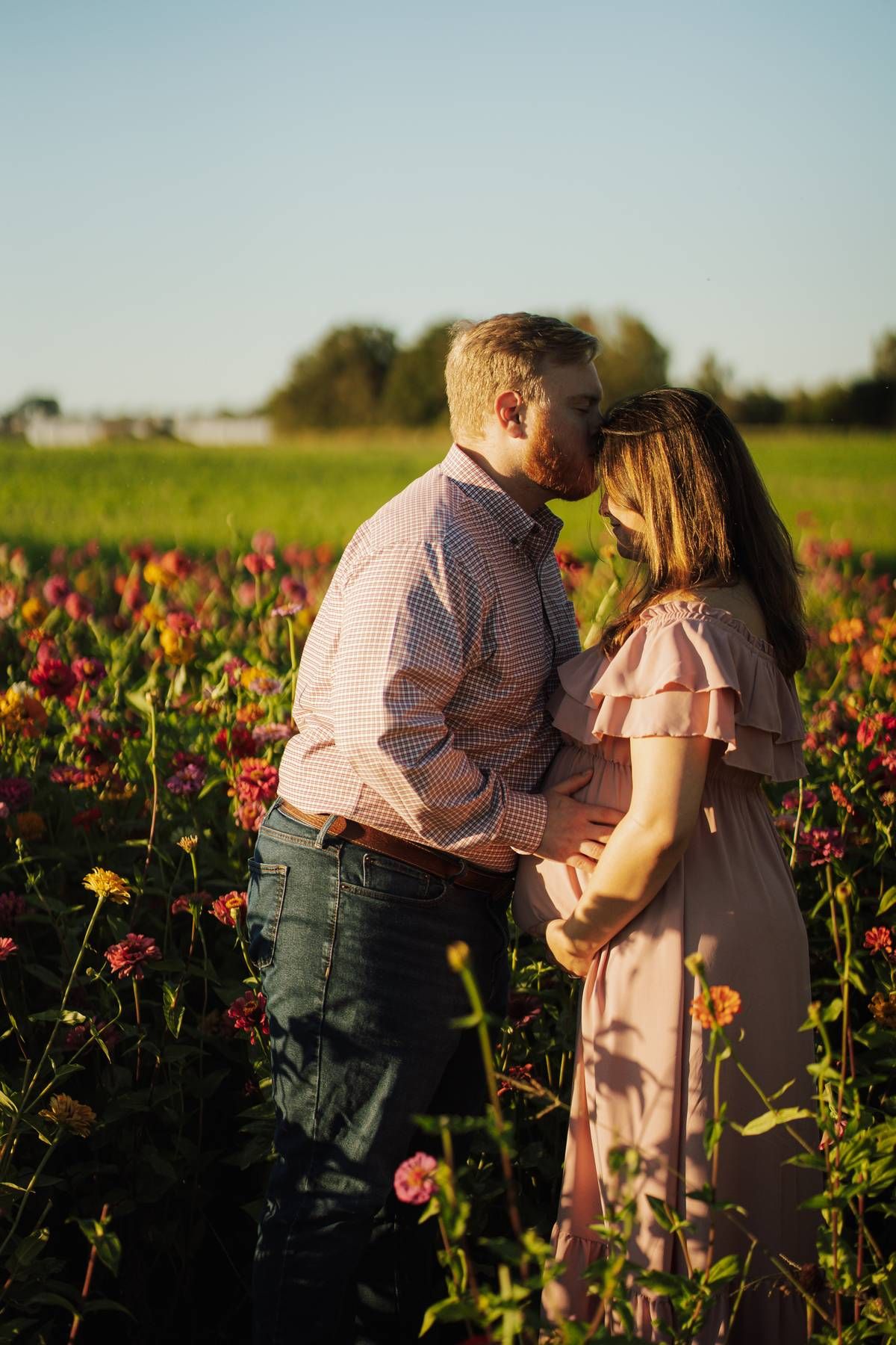 pregant couple in a grassy field
