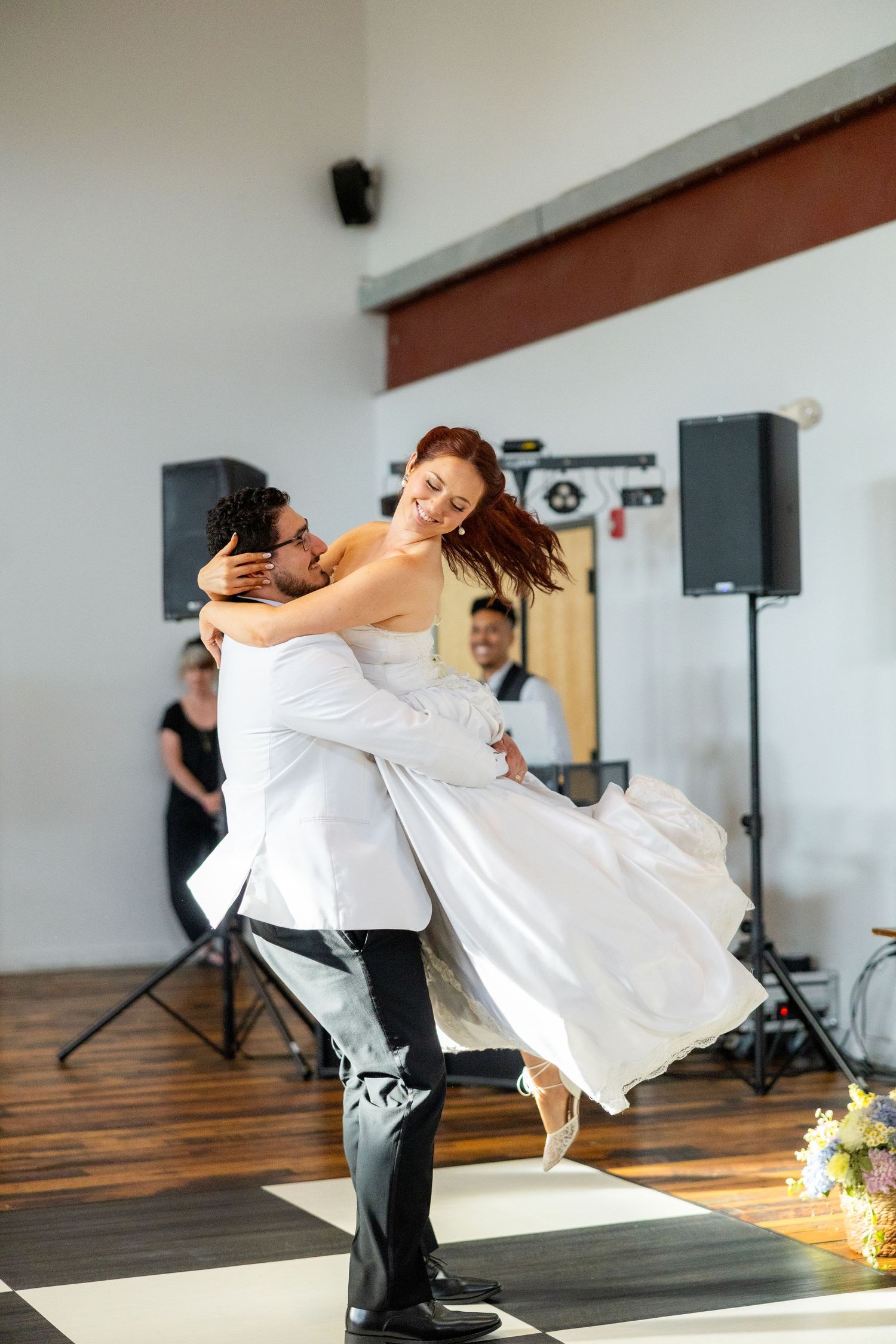 a groom picking his wife up on the dance floor
