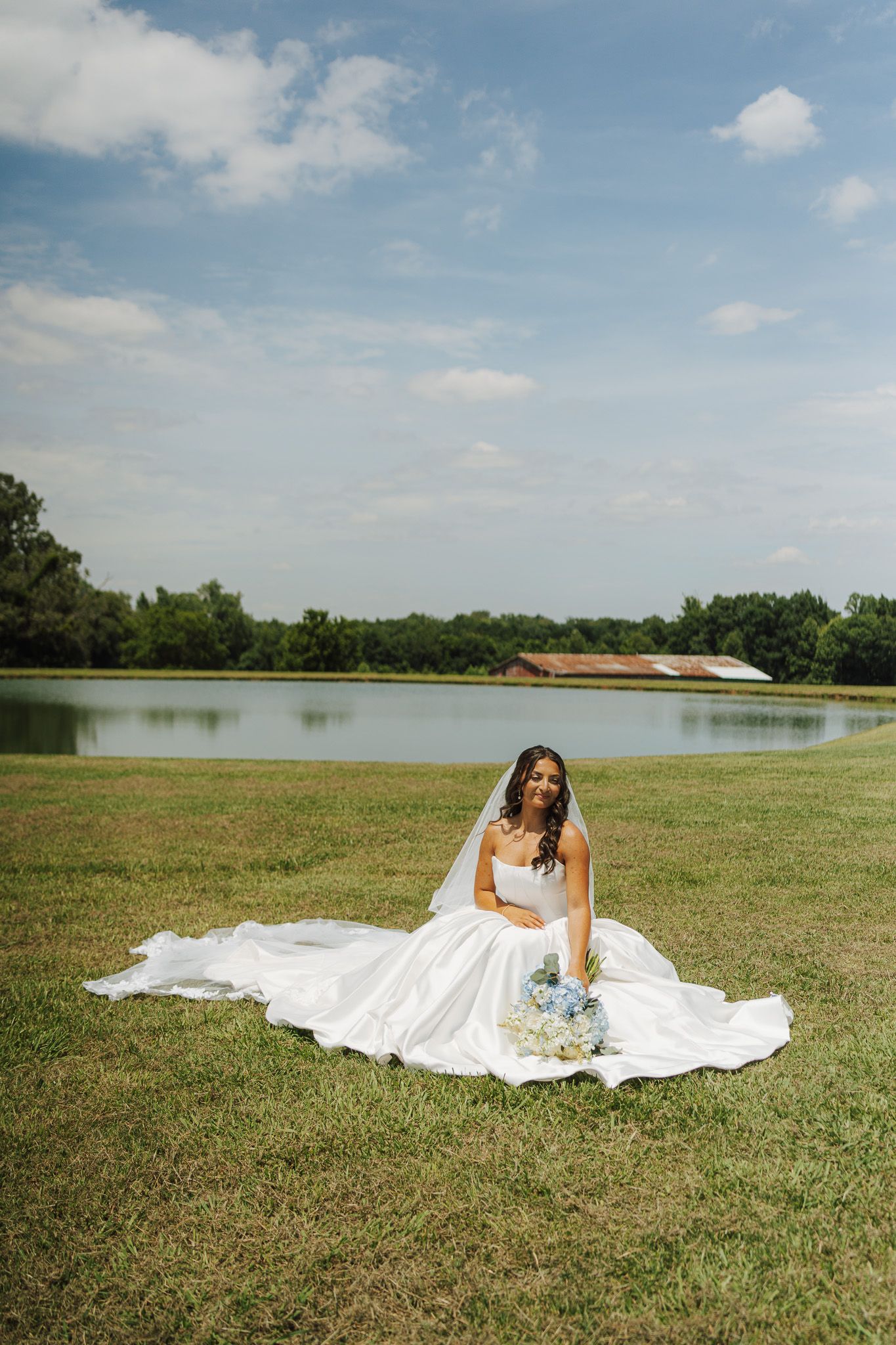 bride sitting in a grassy field