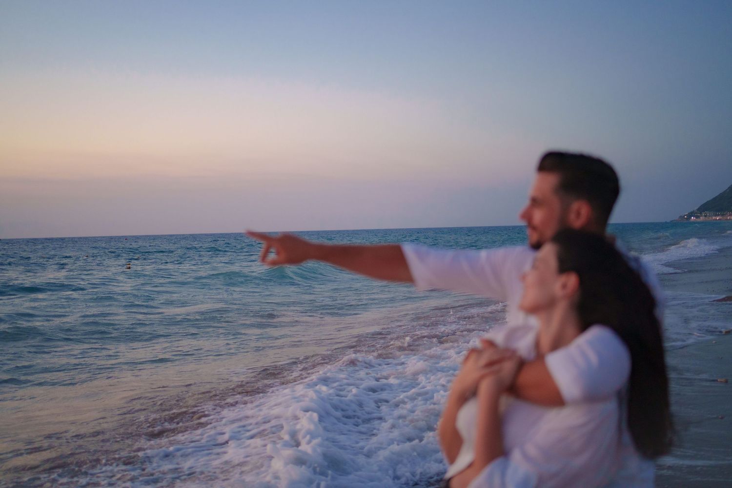 a couple standing near the ocean