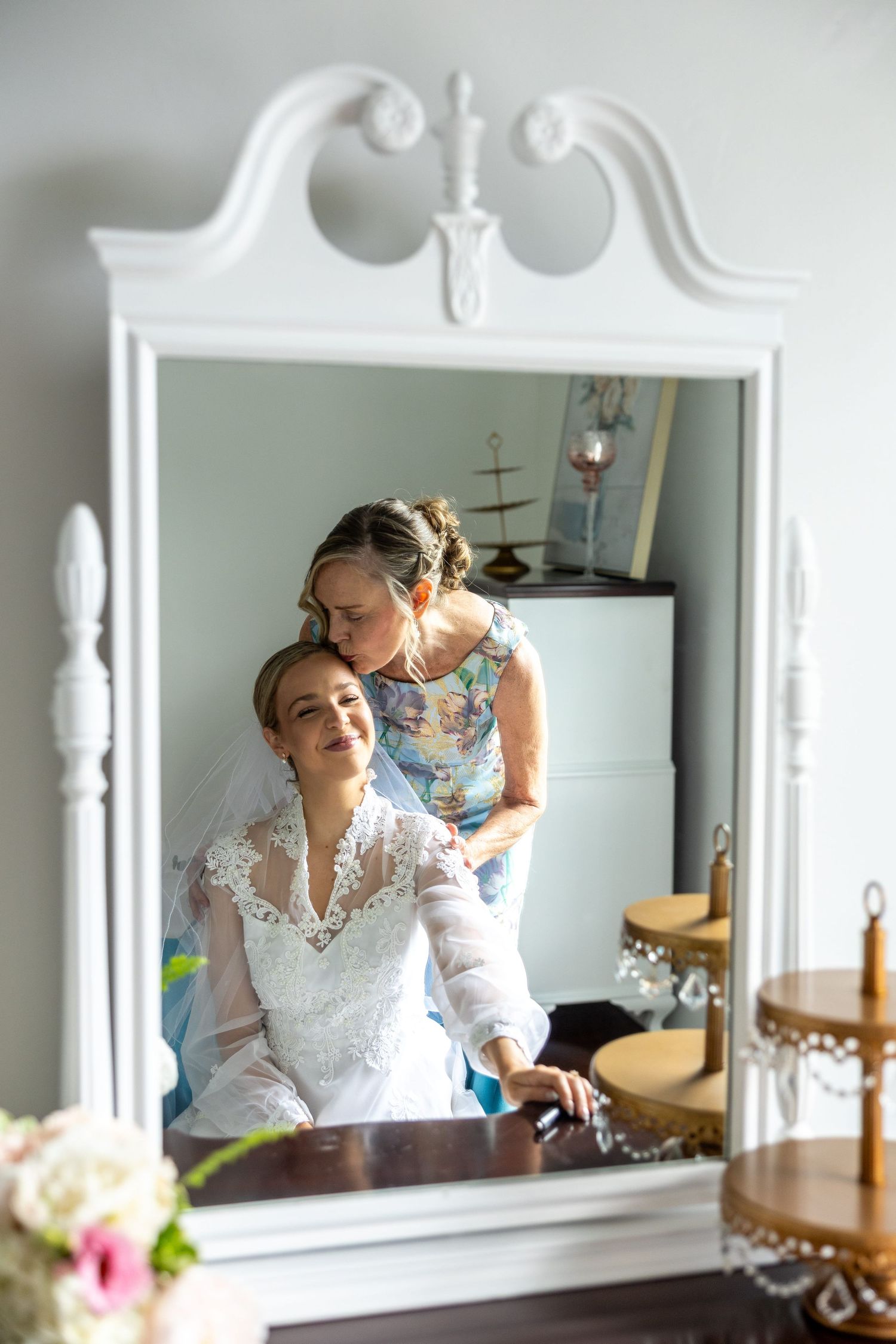 a mom kissing her daughter on her wedding day