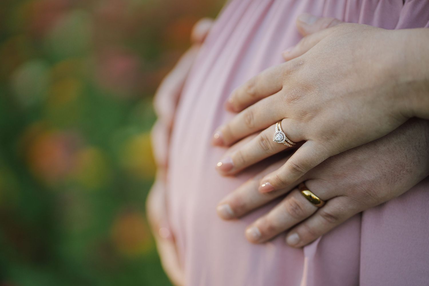 husband and wife holding the stomach of the pregnant wife during their photo session