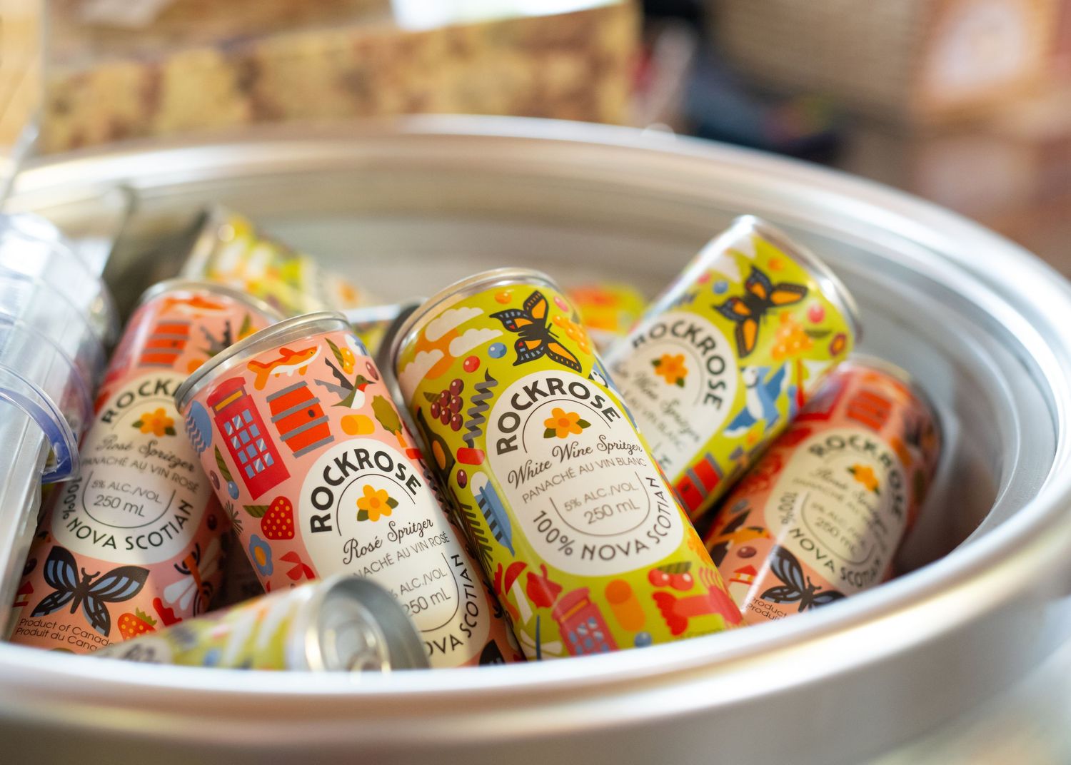 Colorful Rockrose Nova Scotia canned drinks chilling in a round metal ice bucket.