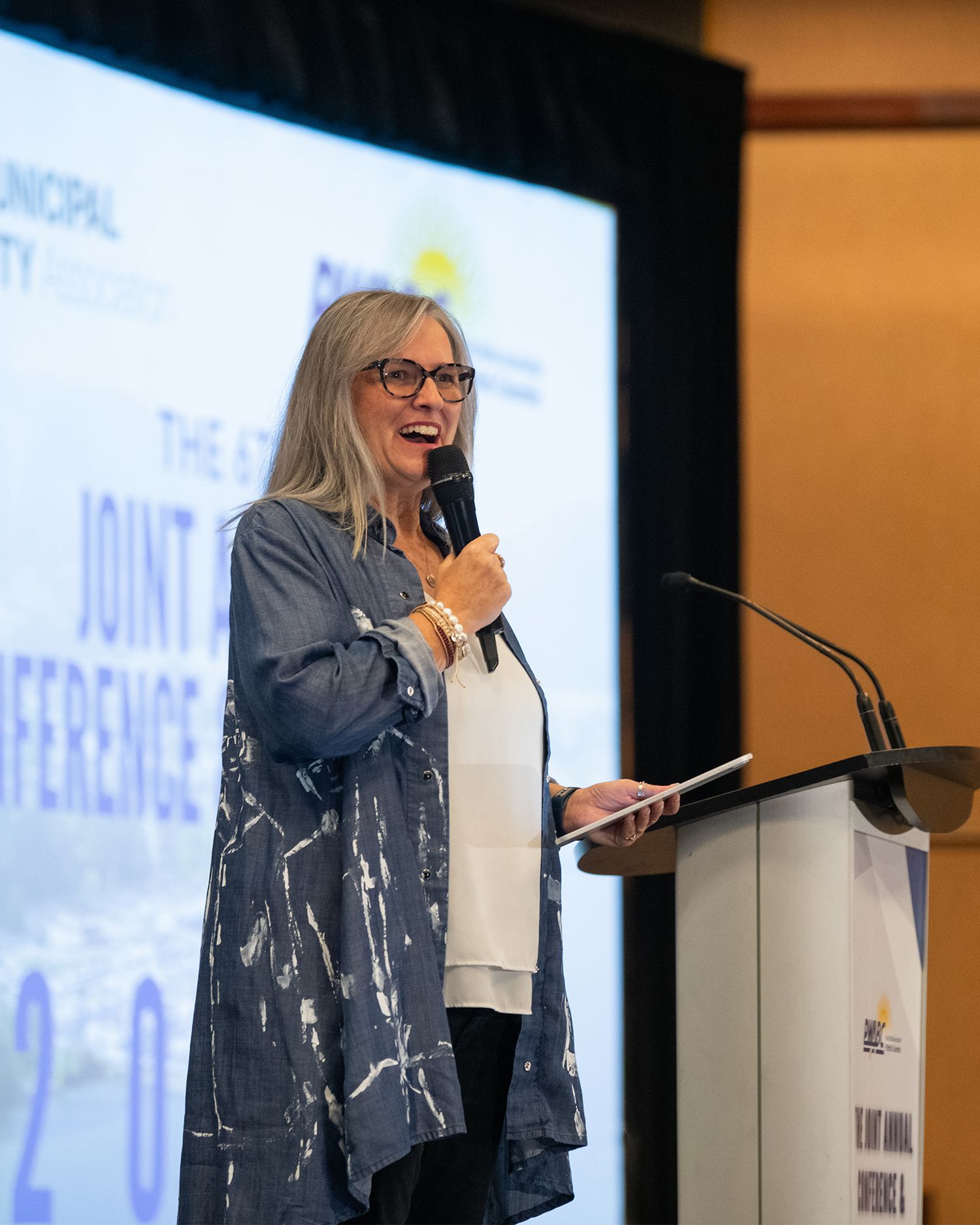 Conference speaker holding microphone at the 2023 Joint Annual BCMSA/PWABC Conference in Penticton, BC.