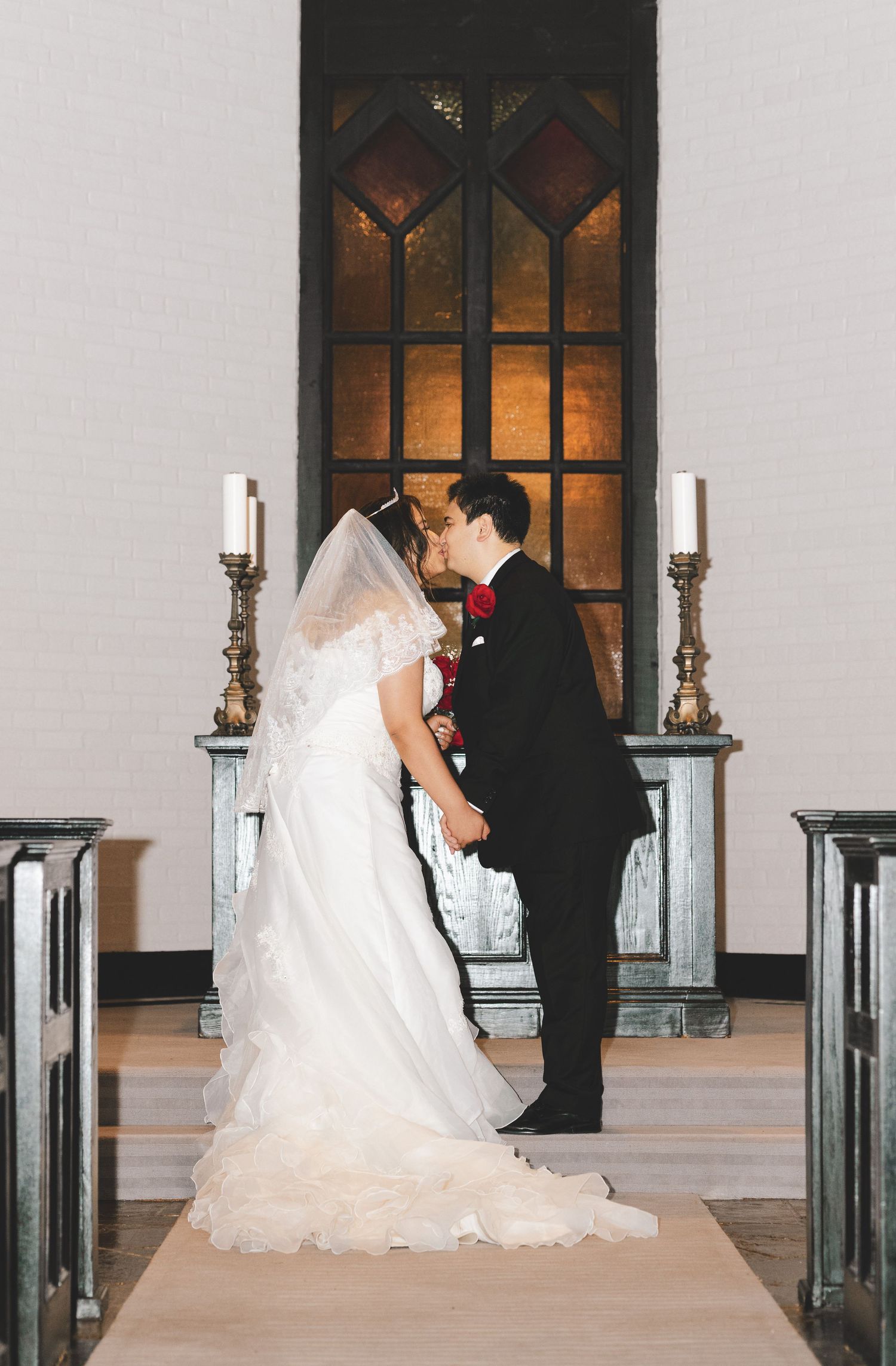 A romantic wedding series showing a couple in formal attire sharing tender moments near elegant windows with candlesticks.