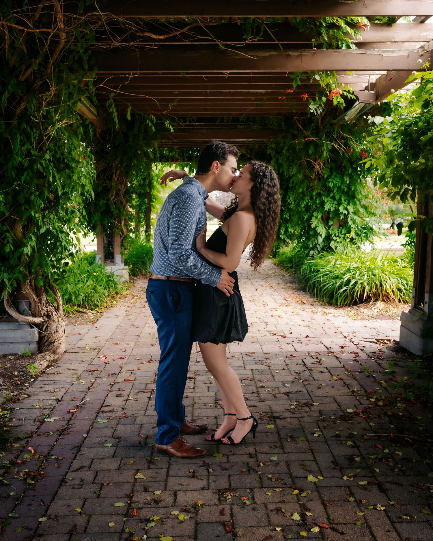 Romantic silhouettes captured in sequence under a garden pergola with climbing vines and brick pathway.