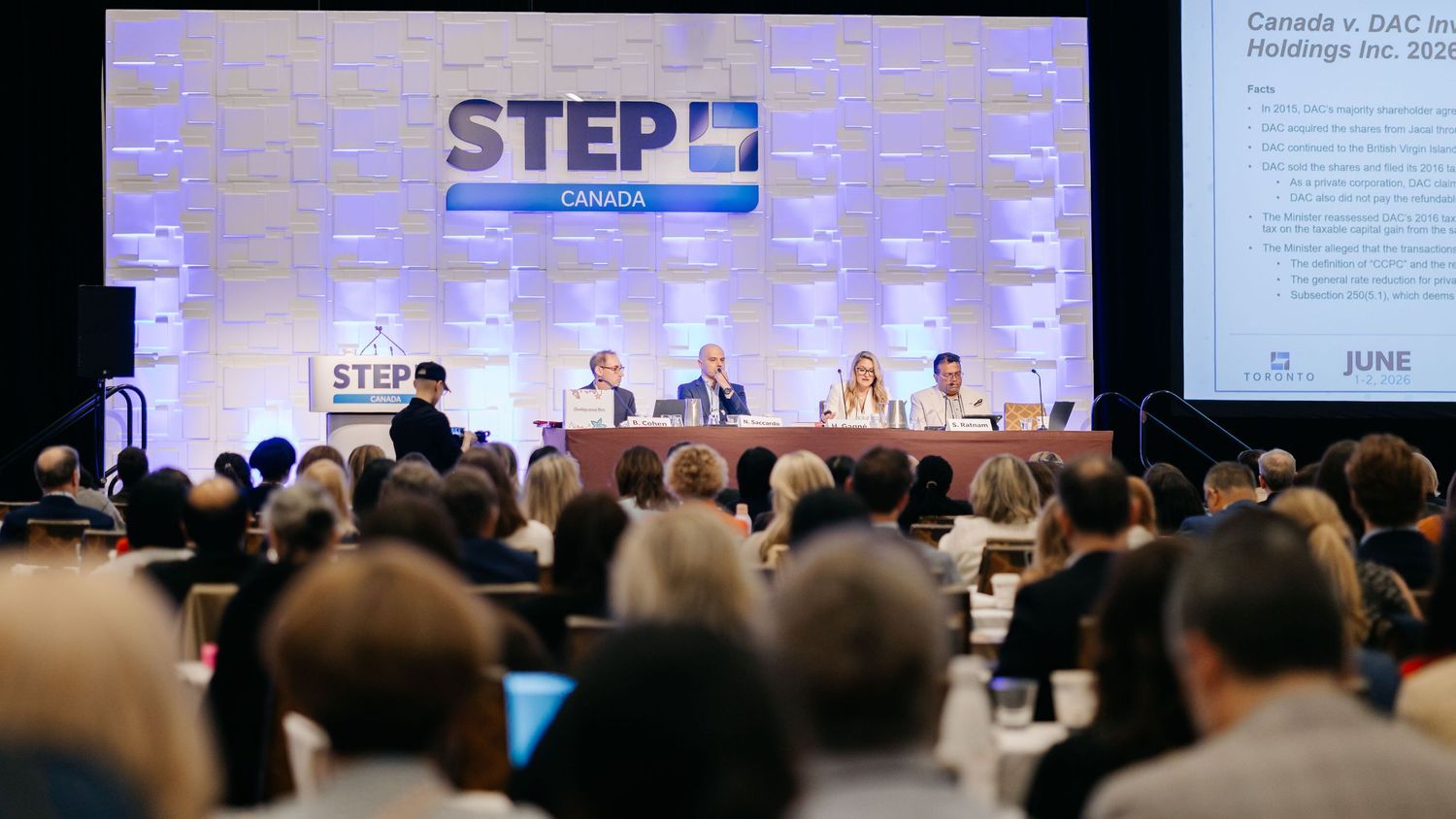 STEP Canada conference panel discussion with speakers at a podium before a large audience in a professional setting.