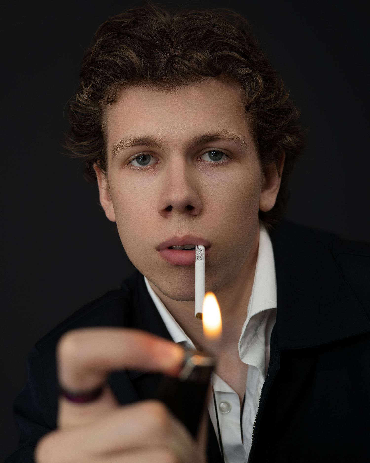 Sequential photos show someone lighting a cigarette against a dark background, captured in dramatic black and white lighting.