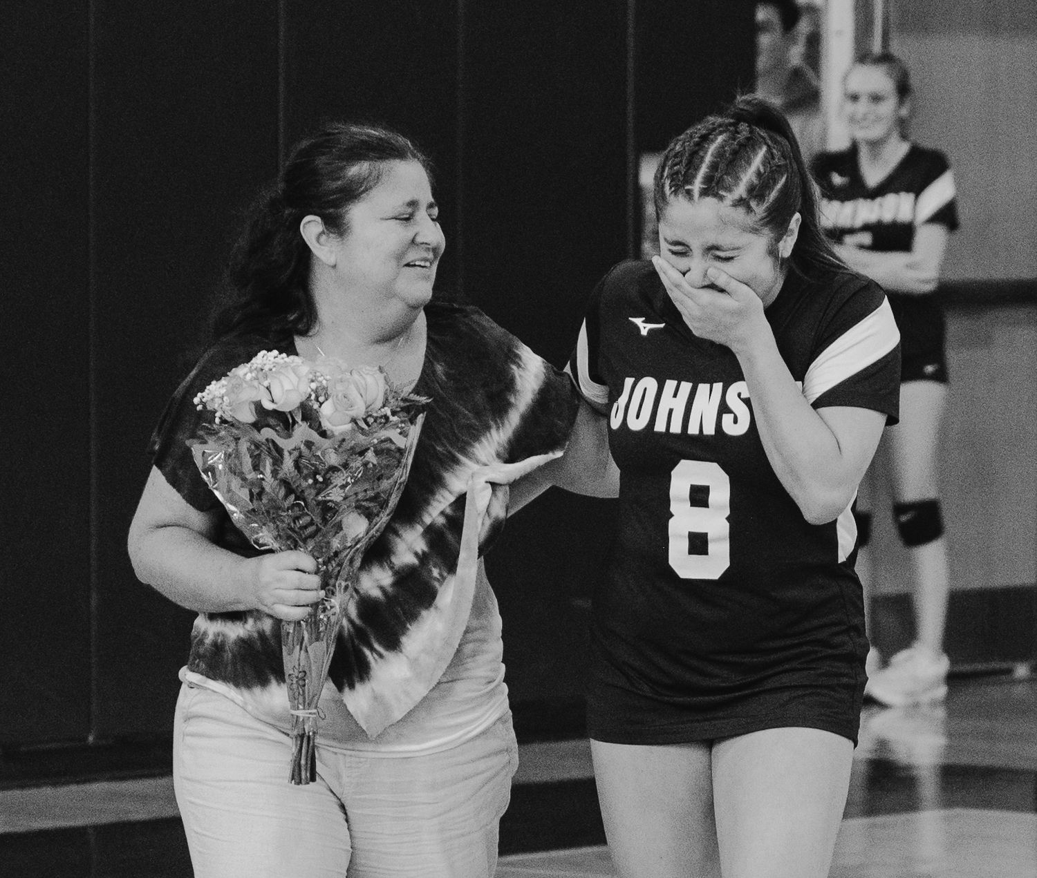 Volleyball team members in Johnson uniforms during a game huddle.