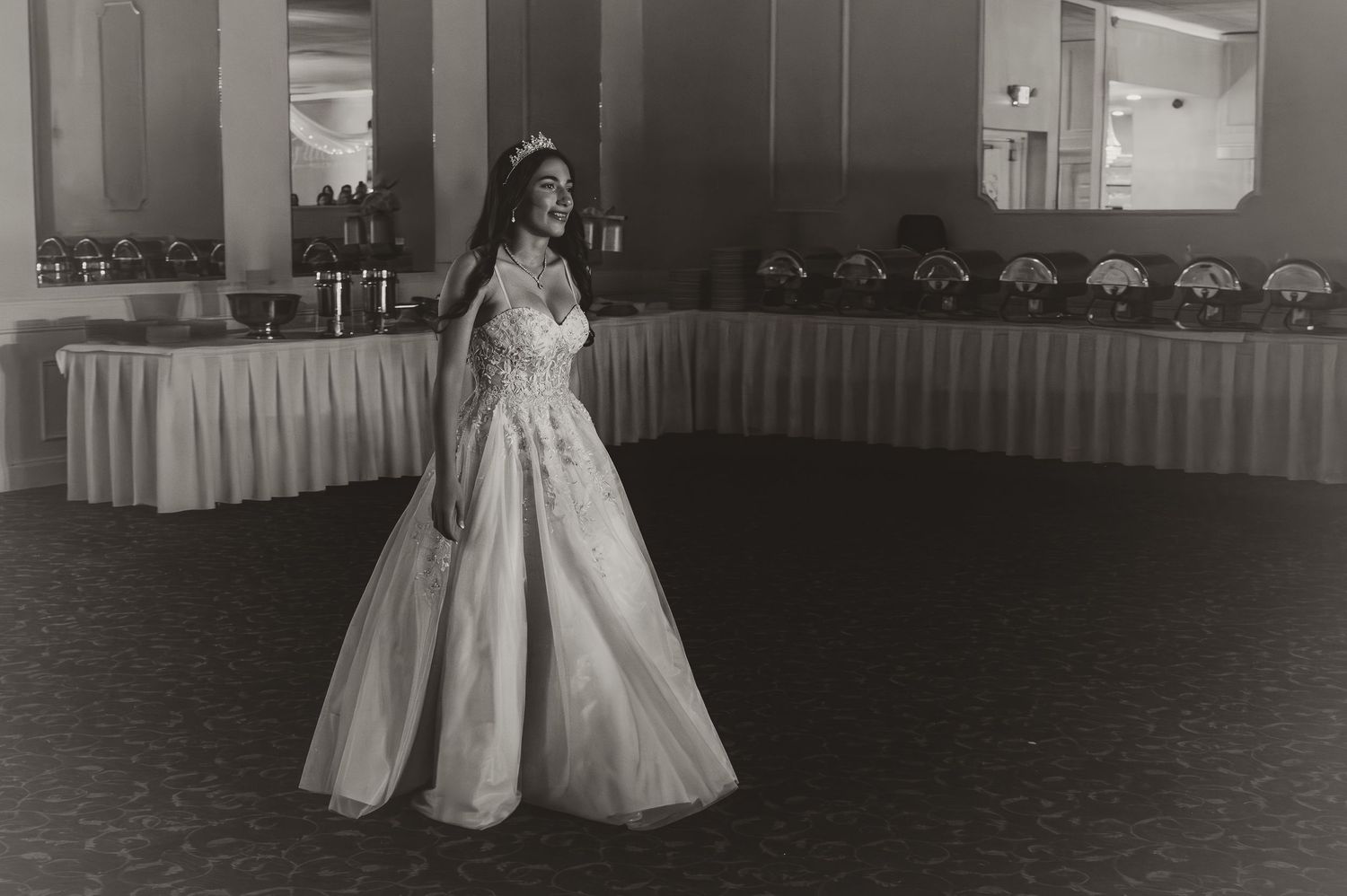Vintage black and white photograph of a formal gown in a ballroom setting.