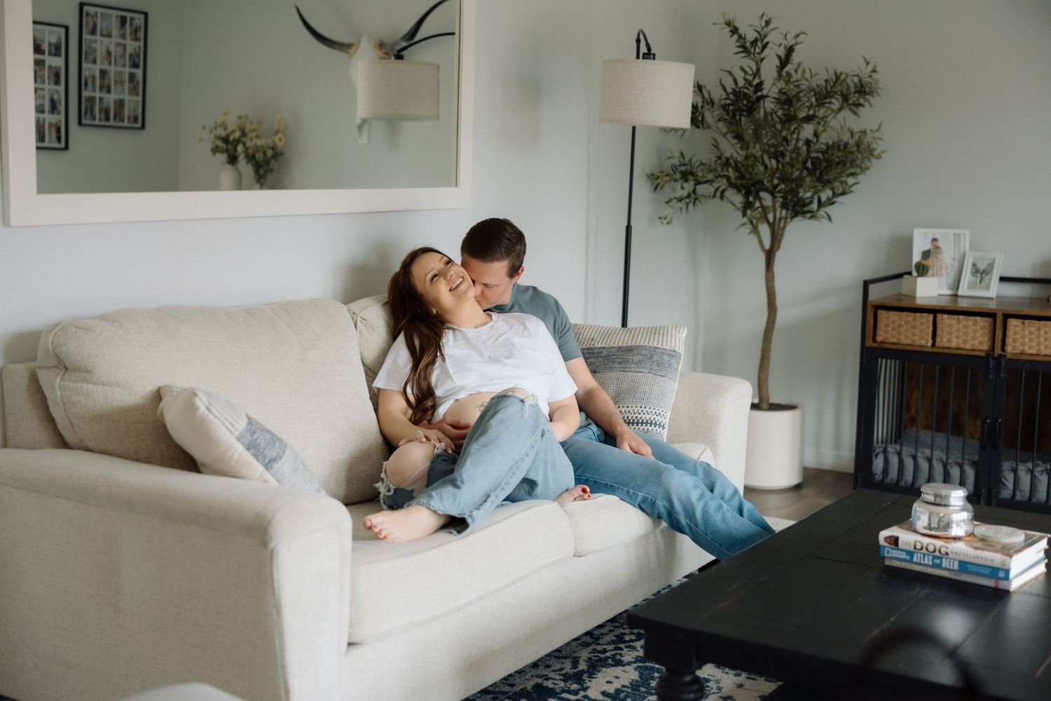 Cozy lifestyle photos of couple relaxing together on grey sofa.