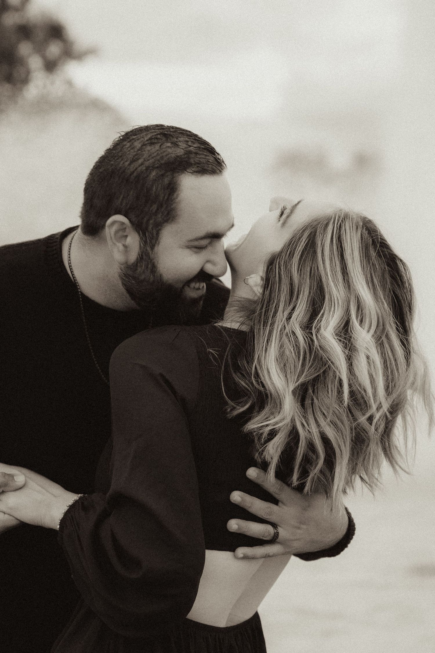 An intimate black and white portrait of a couple sharing a romantic moment in Balboa Park in San Diego, CA.