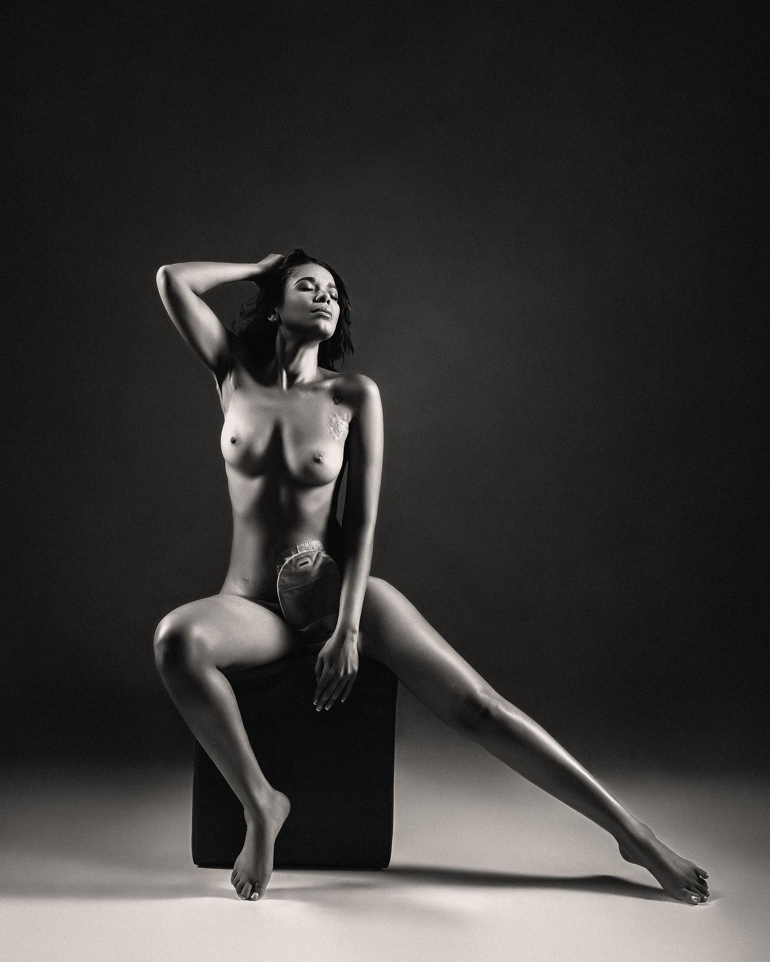 Classic nude art photography in black and white with geometric pose on dark cube. crohn's disease Boudoir Image