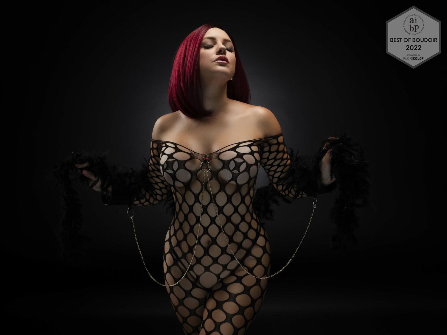 Artistic portrait in dramatic lighting with fishnet pattern dress.