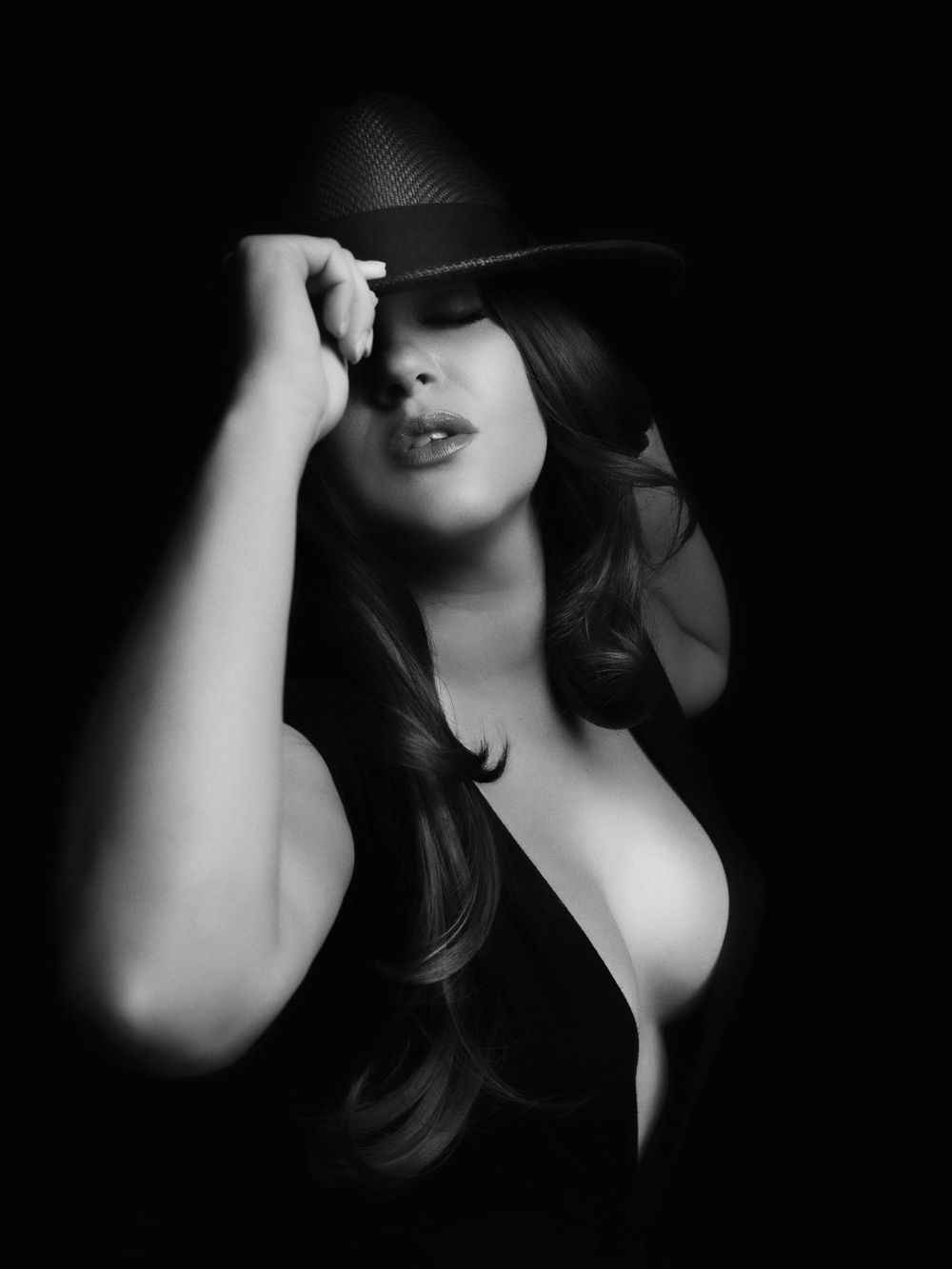 Artistic black and white boudoir portrait series with dramatic shadows and lighting.