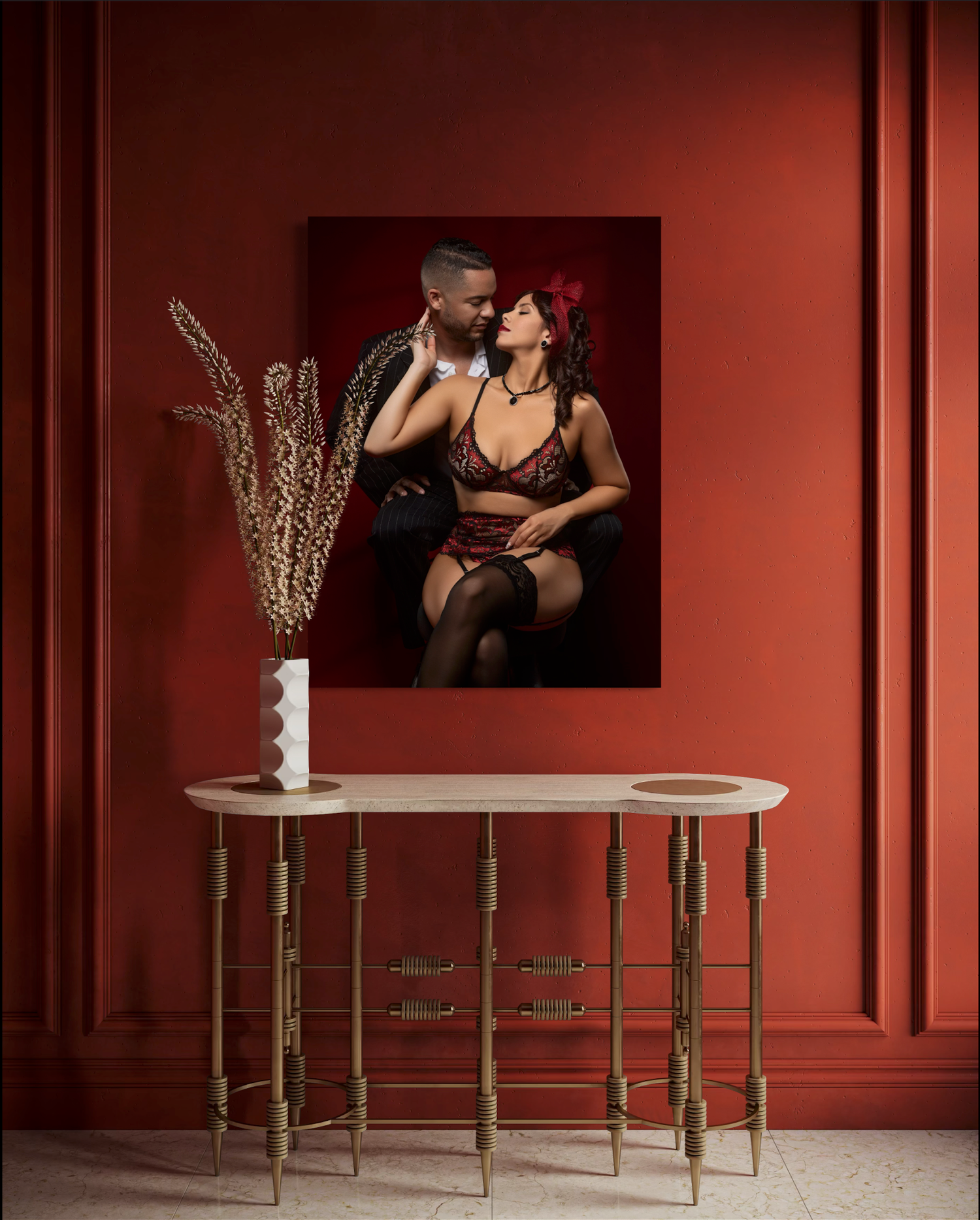Modern interior with red walls featuring artistic photographs and gold accented furniture.