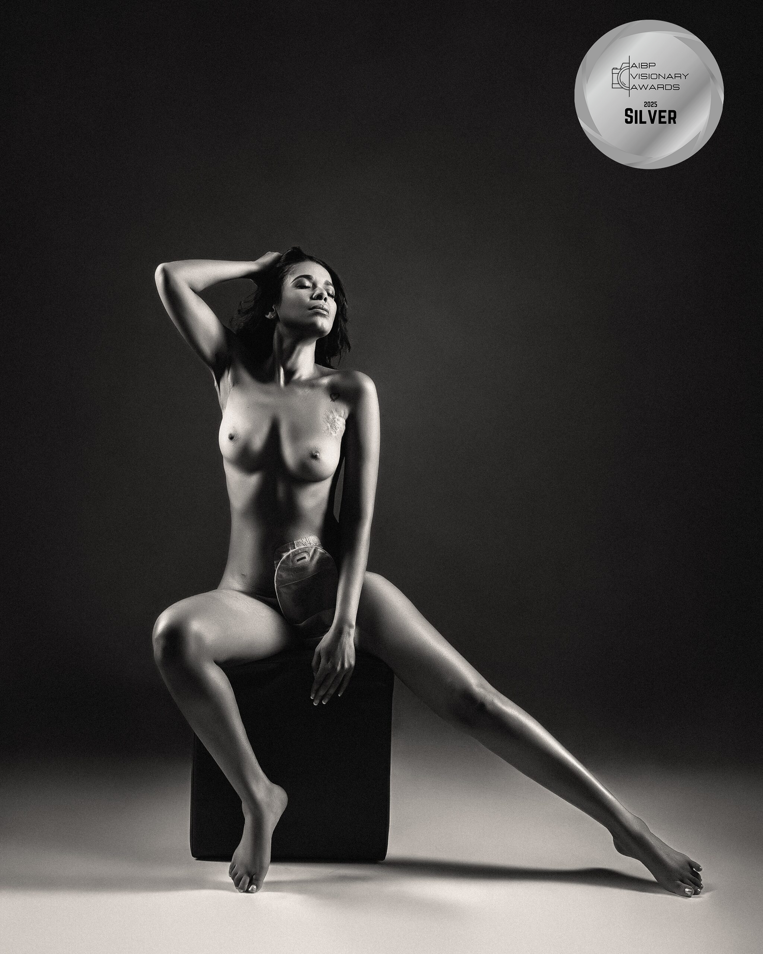 Classic nude art photography in black and white with geometric pose on dark cube. crohn's disease Boudoir Image. AIBP Visionary Awards