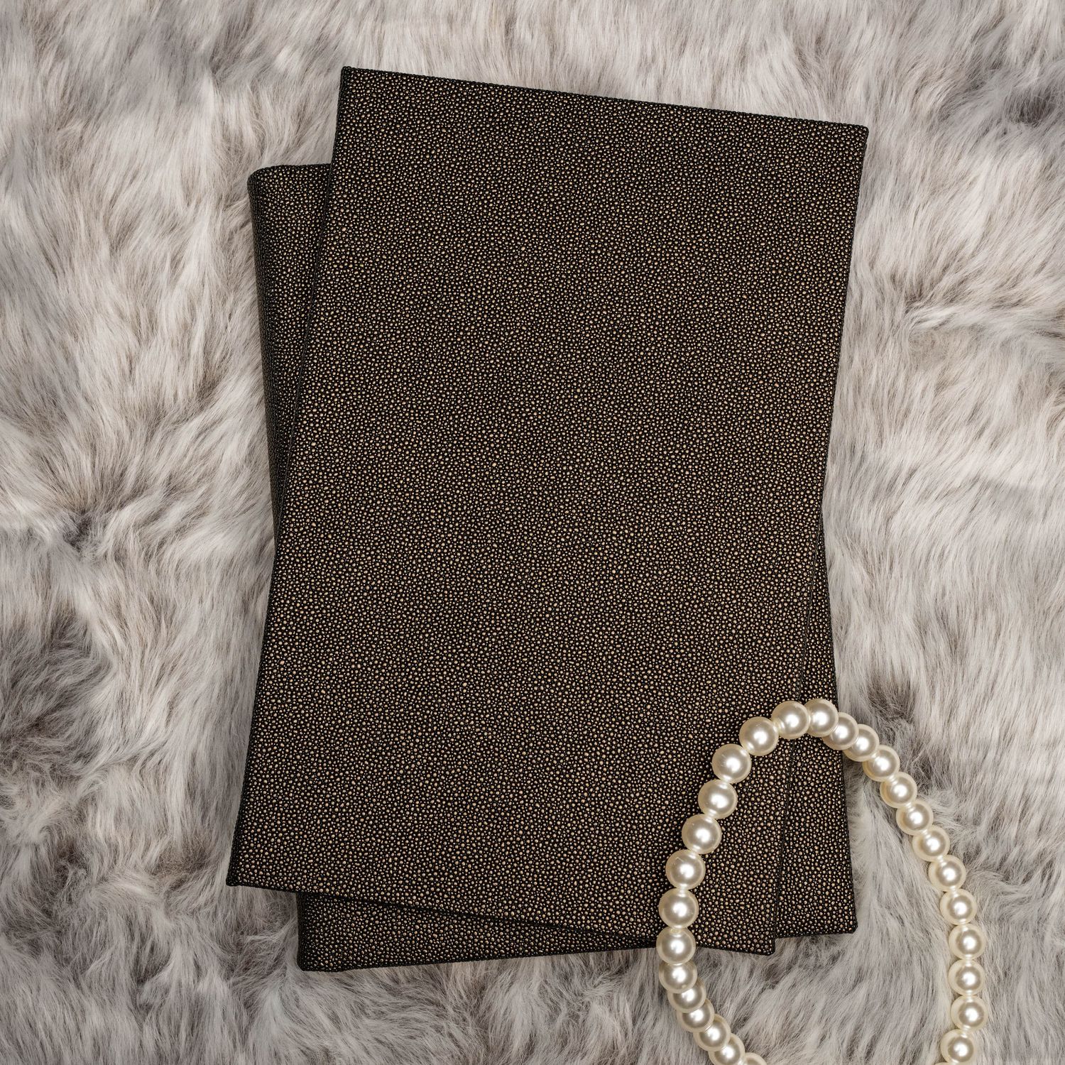 A series of photos showing a pearl bracelet being assembled step by step on a soft furry gray background.