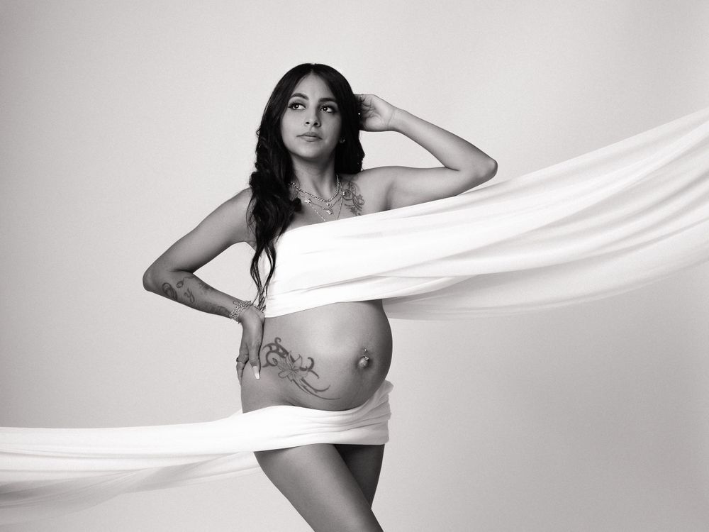 Artistic maternity photos with flowing white fabric against light background creating ethereal effect.