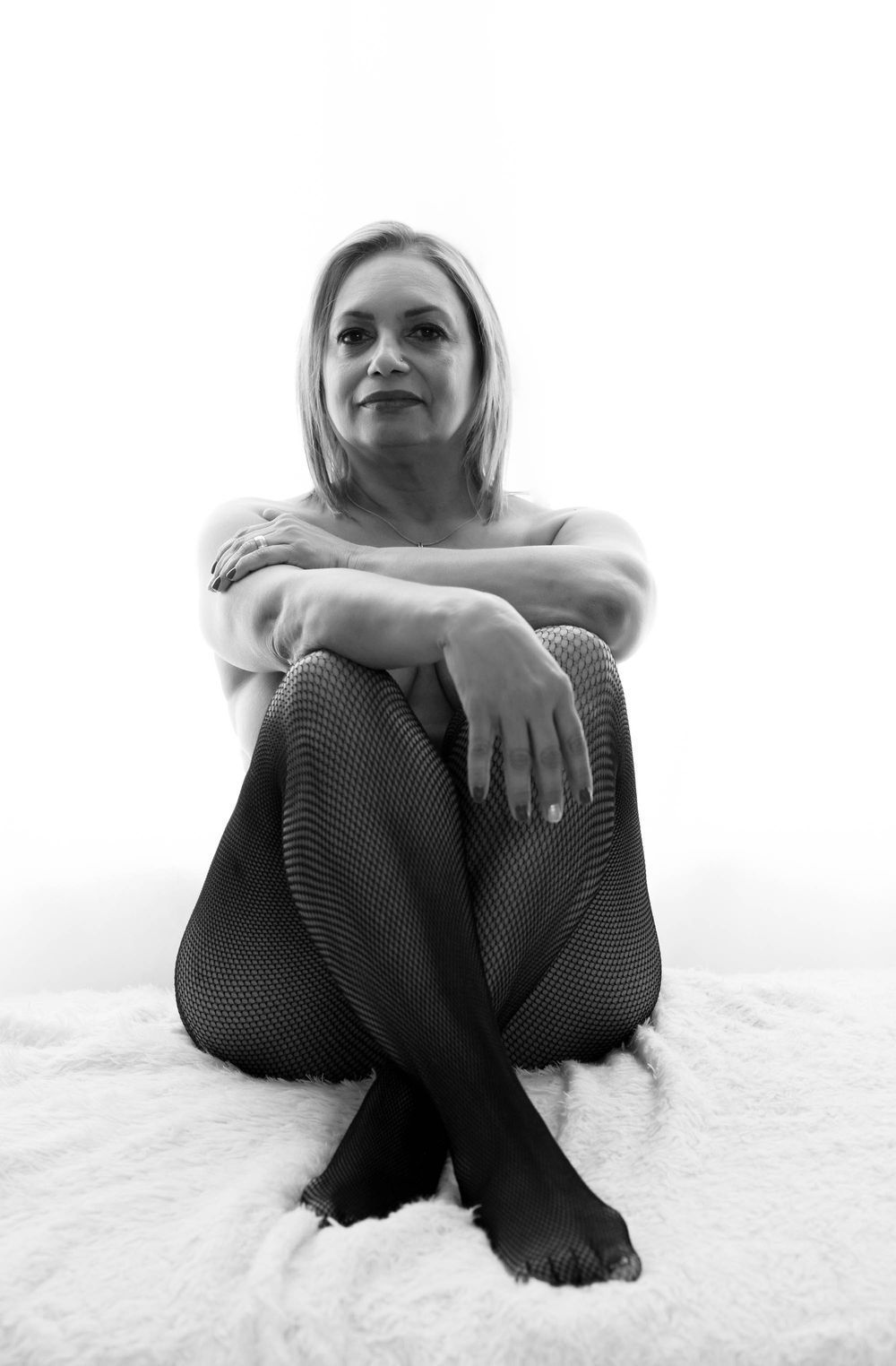 High key black and white portrait series showing relaxed poses against white backdrop.
