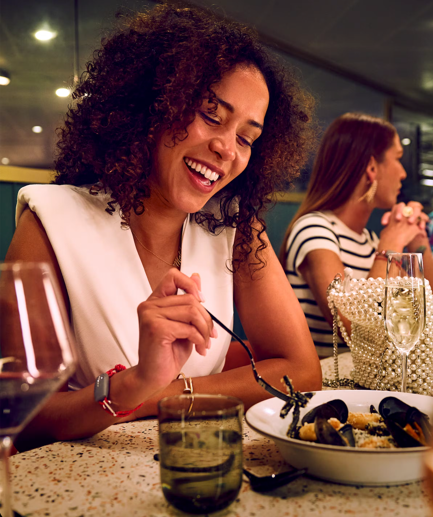 A person enjoying a meal at a restaurant table with a polka dot tablecloth and ambient lighting.