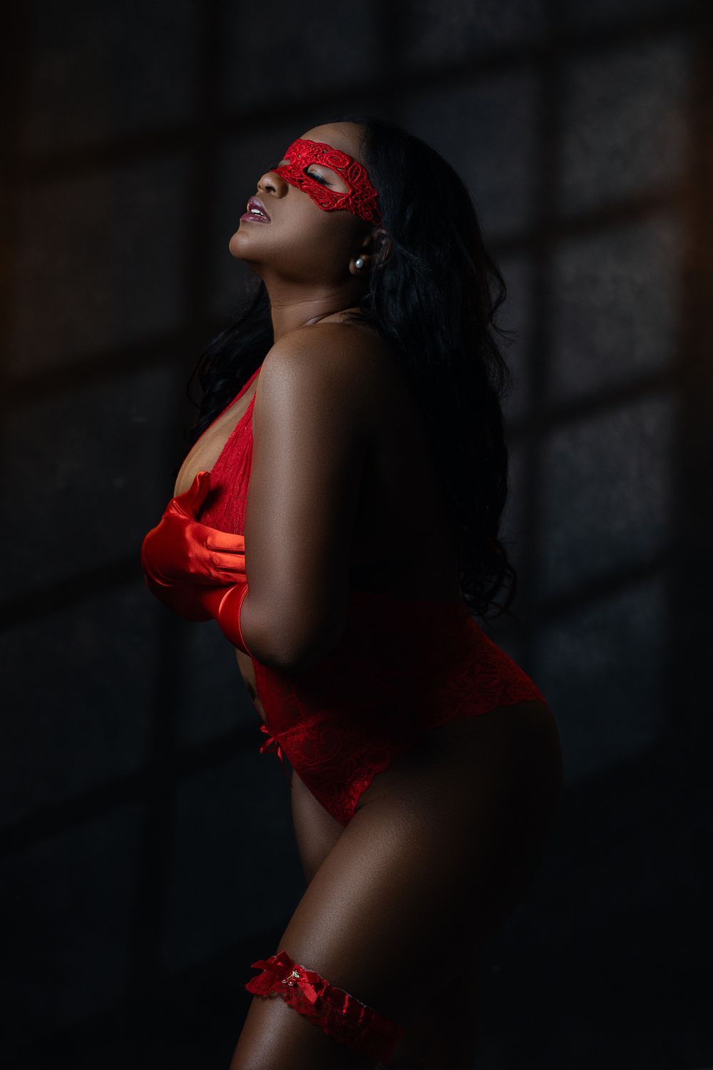 Dramatic portrait in red featuring artistic lighting and intimate styling.