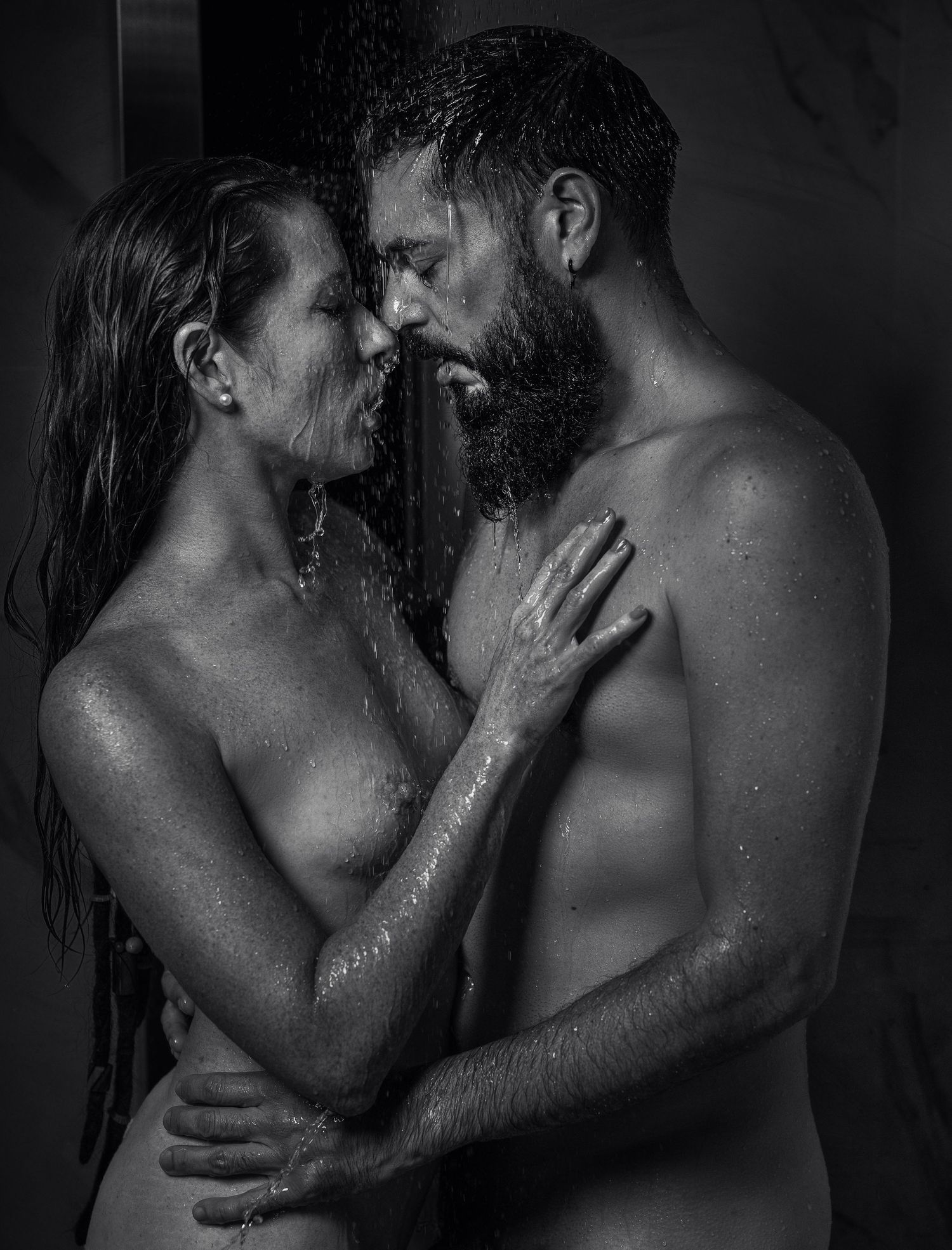 Intimate black and white shower scene with water droplets and dramatic lighting.