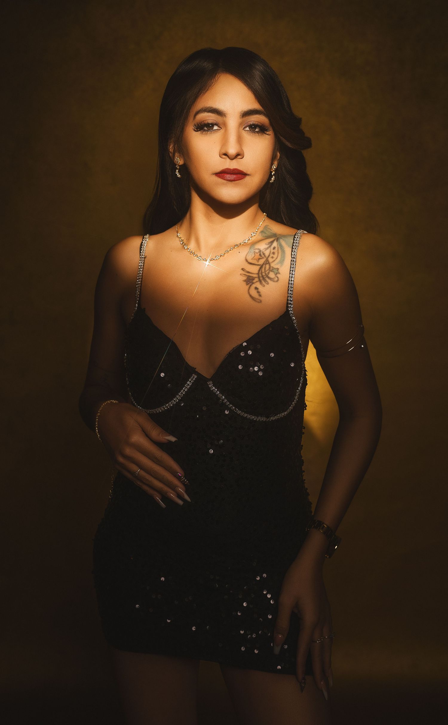 A series of moody portraits in black attire against a dark background with dramatic lighting and shadows.