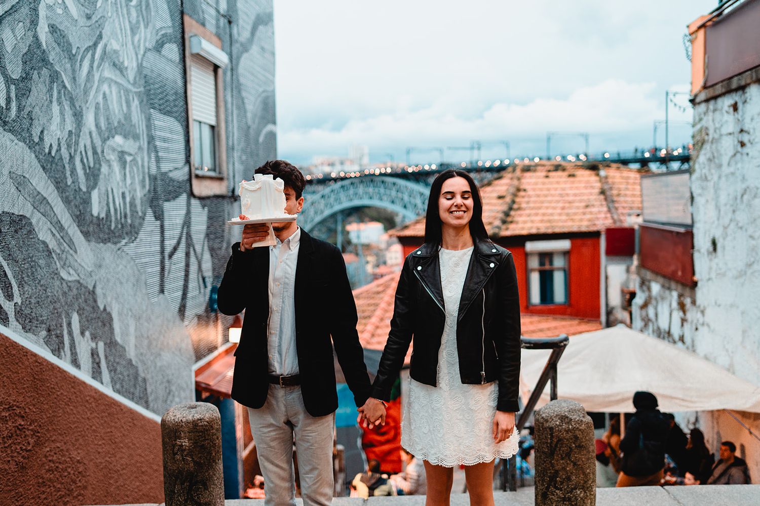 Street style photo shoot against colorful urban backdrop with red rooftops.