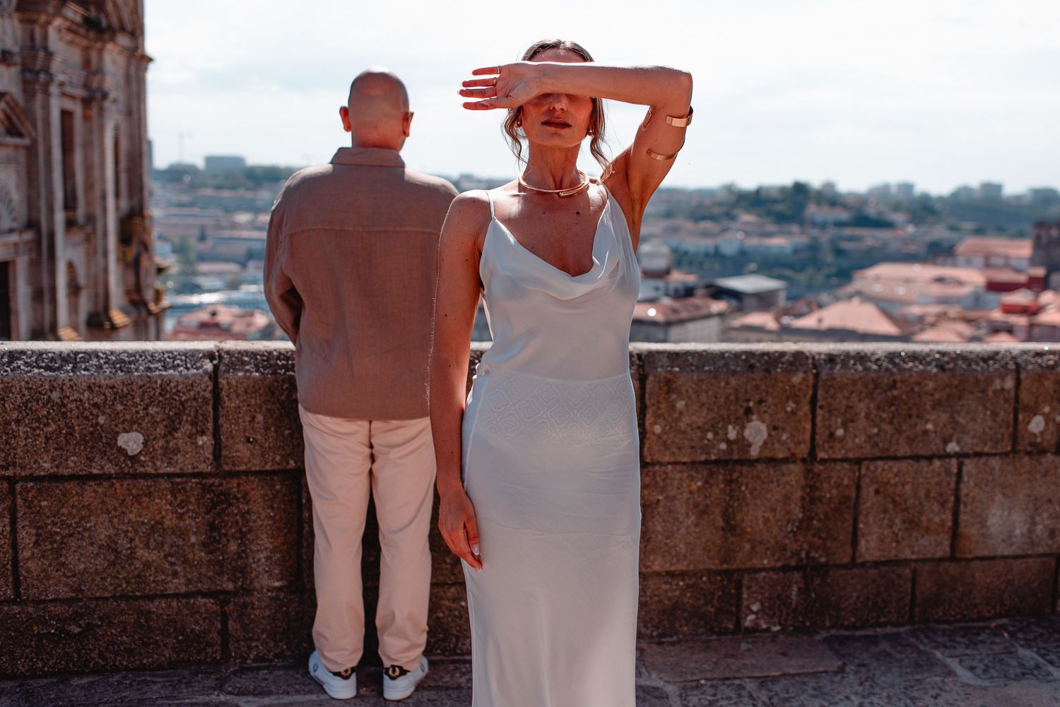 Couple enjoying a romantic moment against an urban backdrop with terracotta roofs.