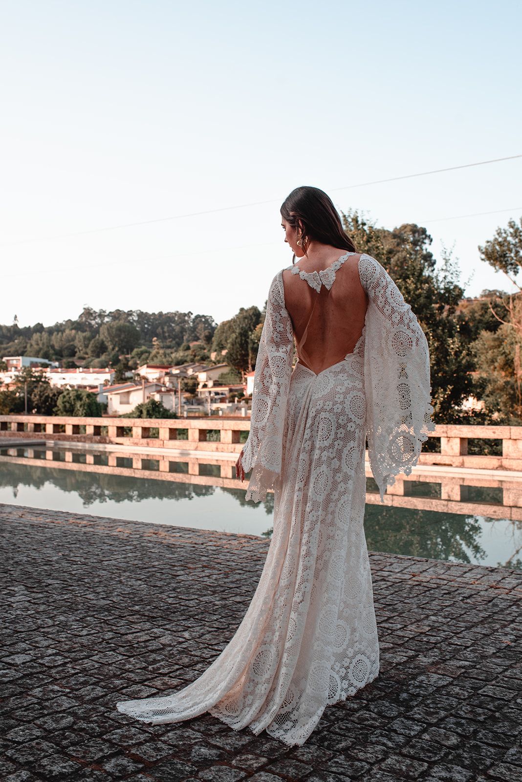 Elegant lace wedding gown with open back detail photographed outdoors.