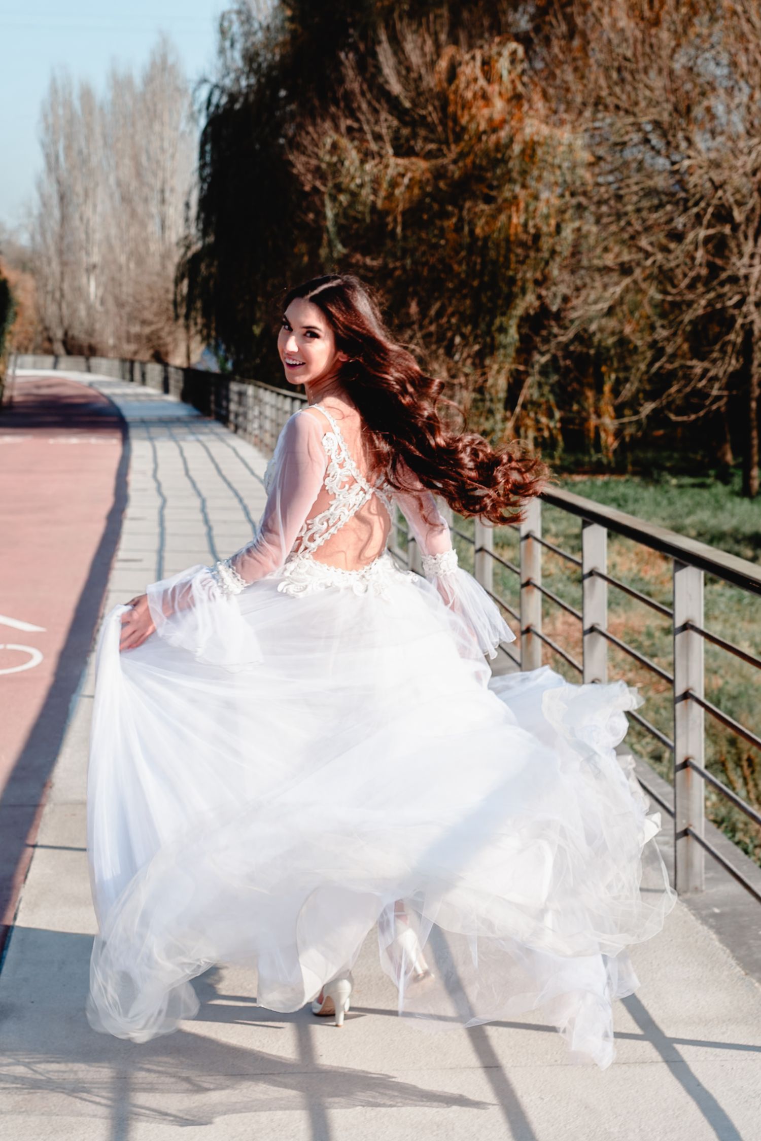Dynamic shots of a white wedding dress twirling on a waterfront walkway.